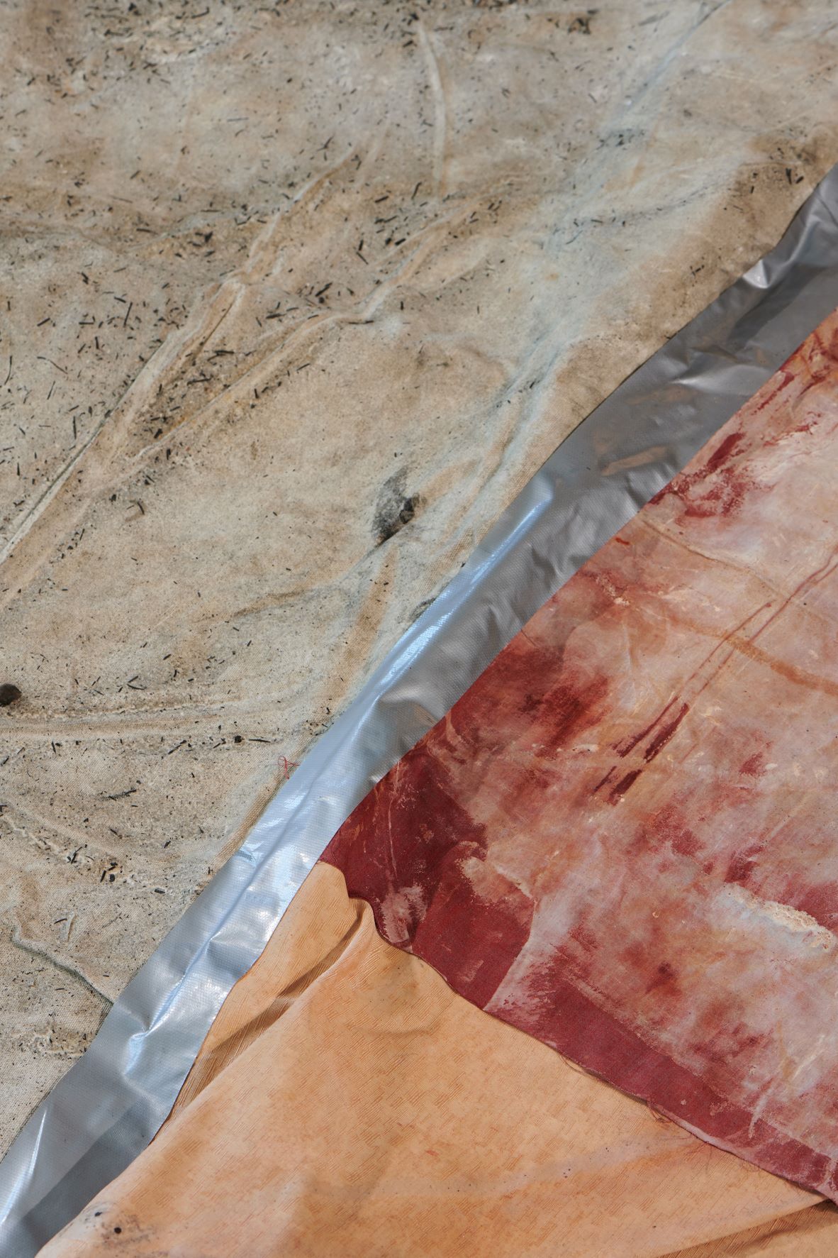 Dala Nasser: Red in Tooth, 2020 – 2021 – 2022 (detail). Discarded fabric, buried underground for 2 weeks to 3 months, ash, charcoal, rainwater. Kölnischer Kunstverein, 2022. Courtesy: the artist and Deborah Schamoni. Photo: Mareike Tocha.