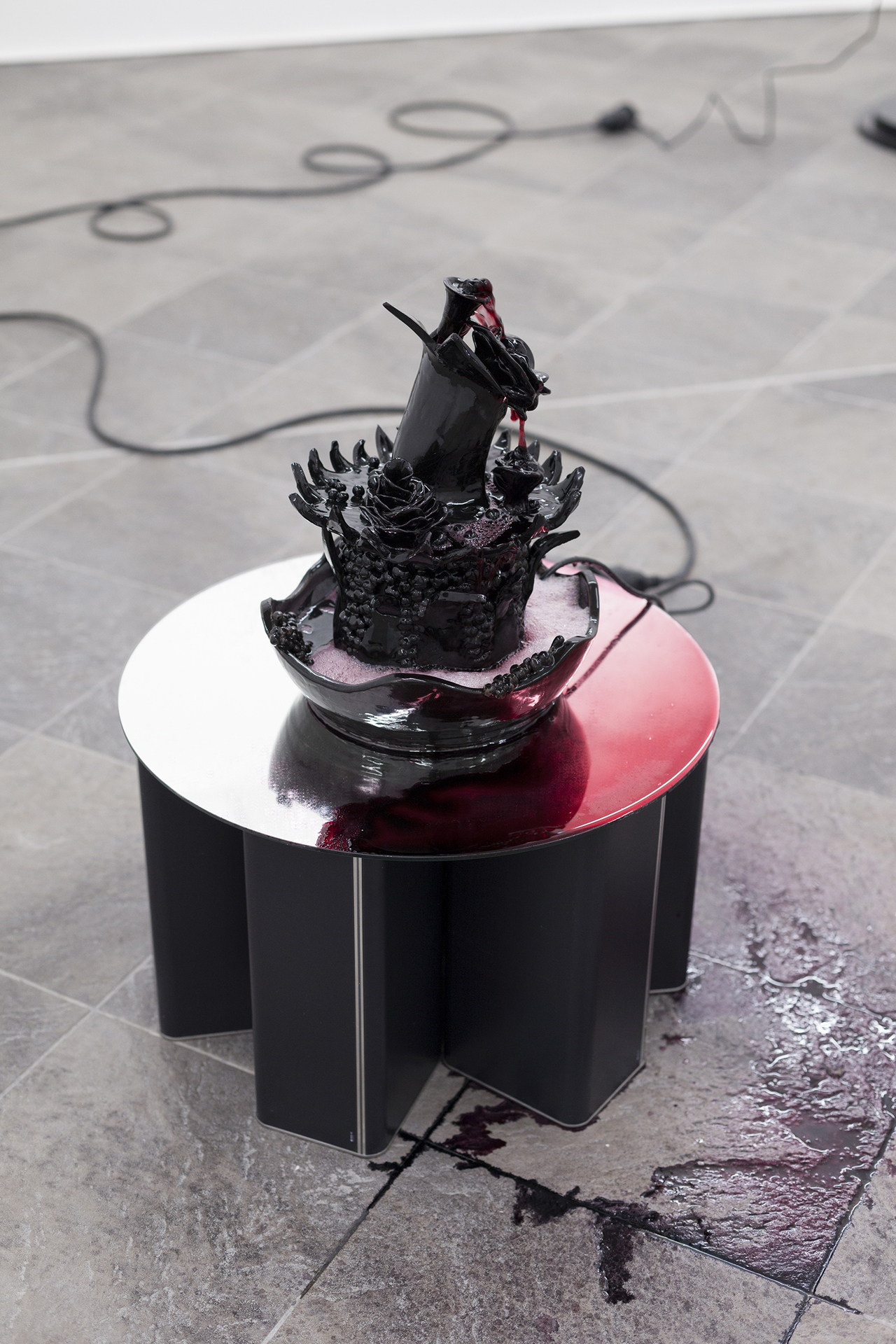 Karoline Dausien, Fountain 2, 2022, glazed ceramics, table, mirror, well pump, red wine