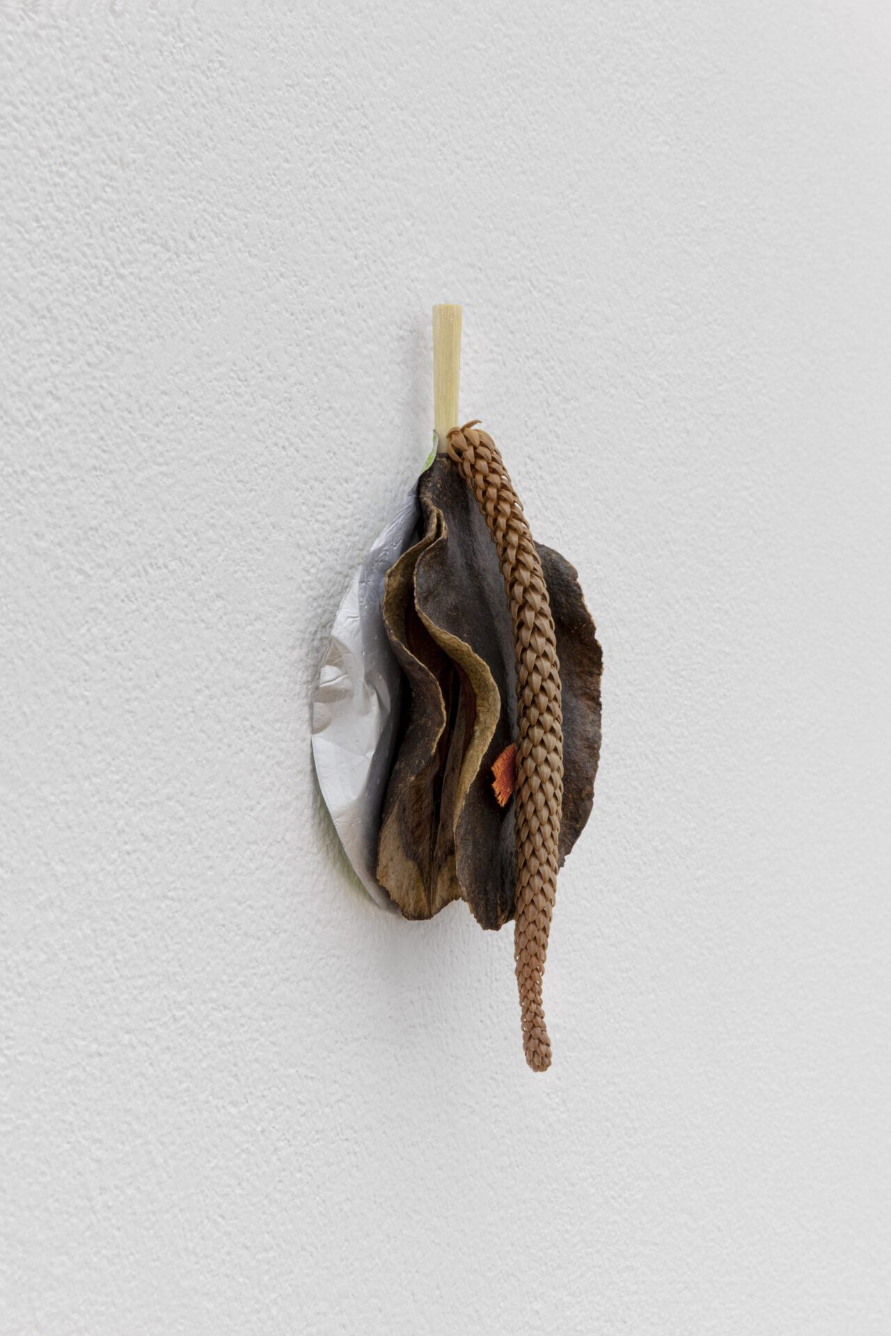 David Fesl, Untitled, 2022, Aluminum yogurt cup lid, bamboo chopstick, dried seeded fruit, parasitic plant, cloth, 13.9 × 6.4 × 2.9 cm