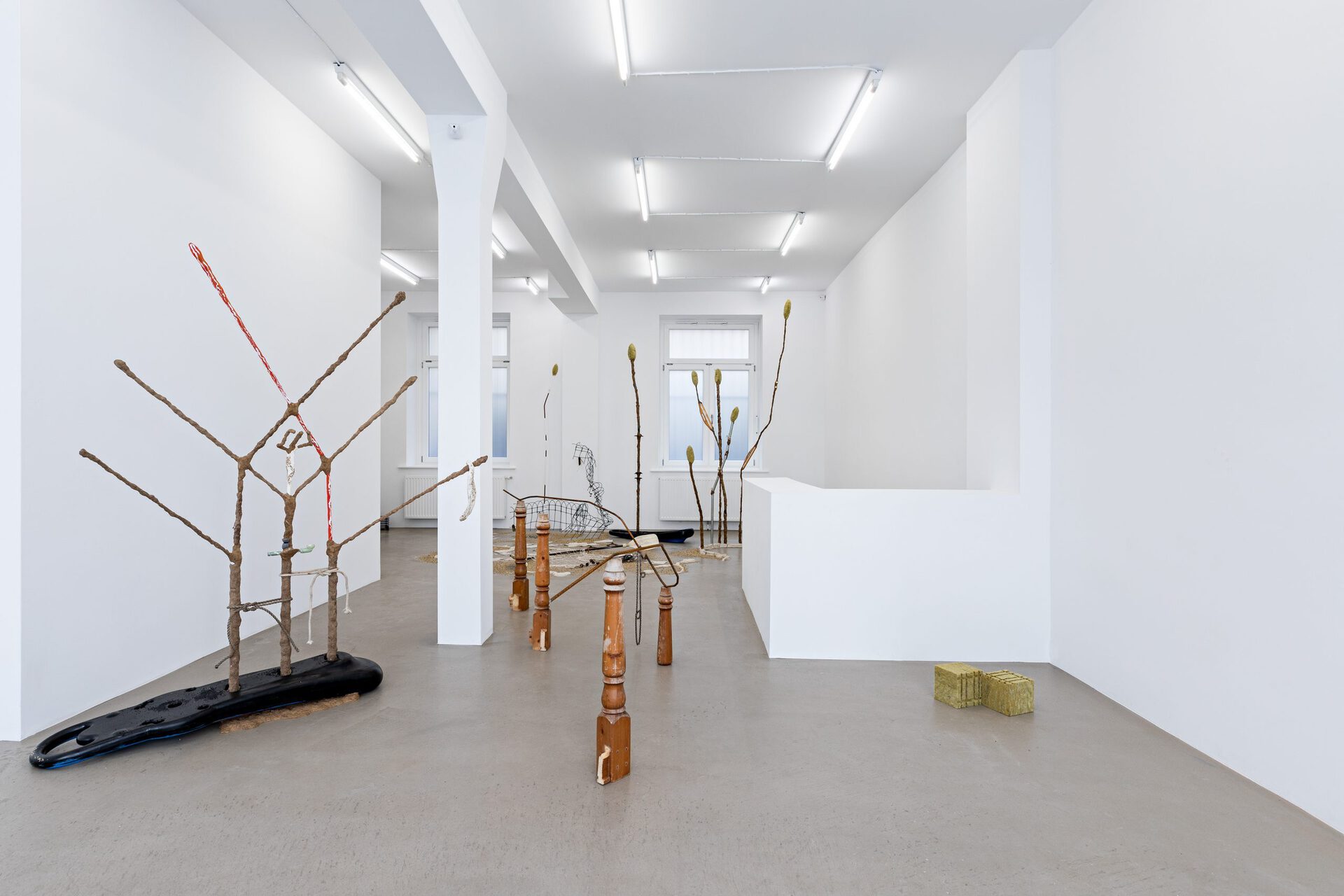 Michelle Chang Qin, Trade Gold for Stone, 2022, Metal, clay, cultiwool, table leg, wire, incense-holder, plastic, chainring, sealant, aquarium-sand, bassin, candlewick, thread, synthetic grapes, bike chain, acrylic, pipe, rope, granules, chair, gold glitter, paddle, fish net, pedal, fence, metal triangles Dimensions variable