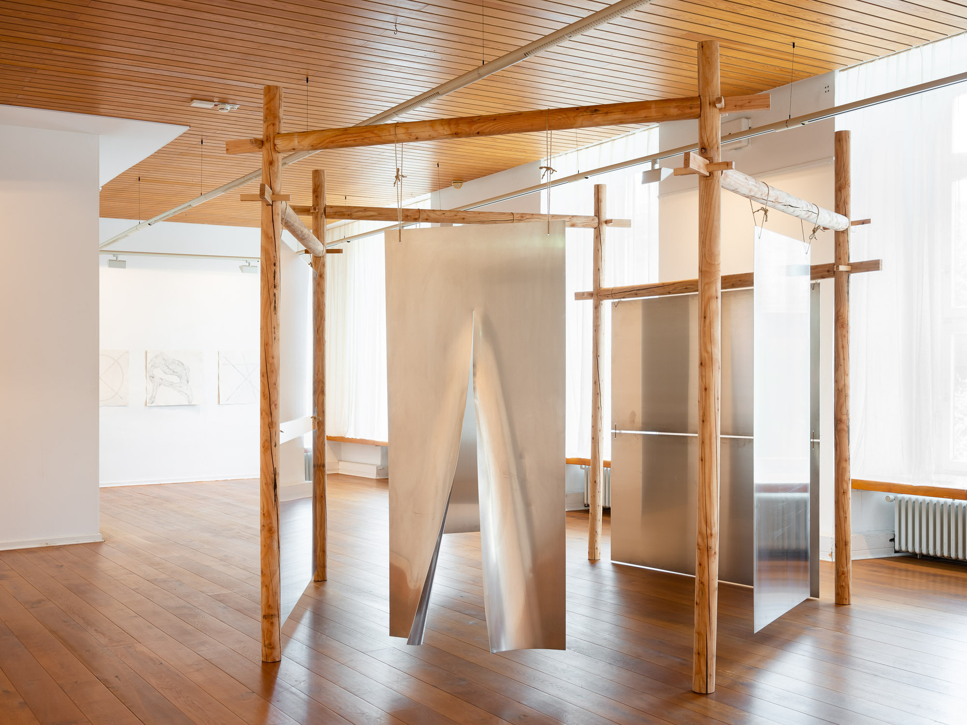 Ellen Martine Heuser, Mausoleum (2018 / 2022), Solid larch wood (cylindrically cut), aluminum plates, rope (290 x 460 x 460 cm)