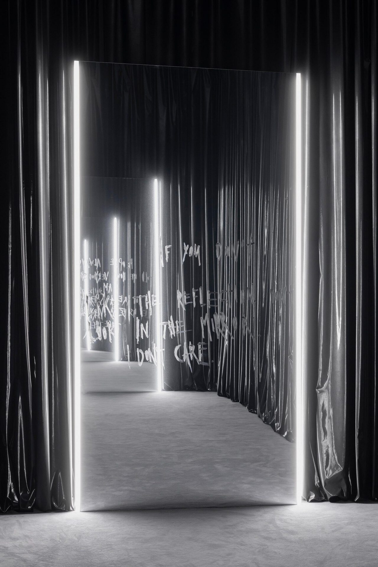 Julian-Jakob Kneer, IF YOU DON'T LIKE THE REFLECTION. DON'T LOOK IN THE MIRROR. I DON'T CARE. (LUKA), 2022, Mirror foil on alu-frame, lipstick, LED lights, metal lacquer on vinyl curtain, mirror: 298 x 156 x 4 cm; curtain: variable dimensions