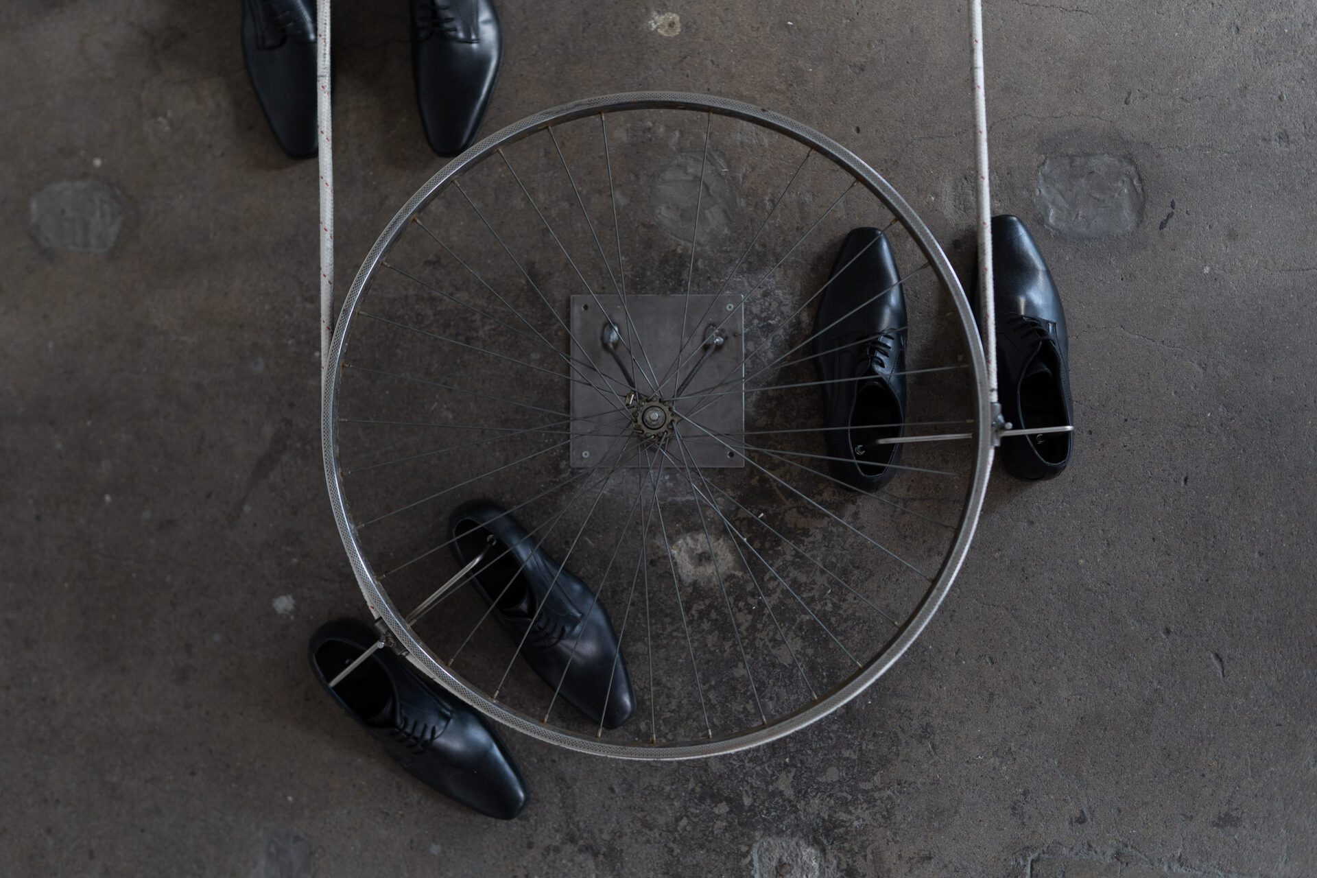 Isabell Ratzinger, Schuhe, 2017, ten pairs of men's business shoes, rope, rims, steel, 370x80x28 cm