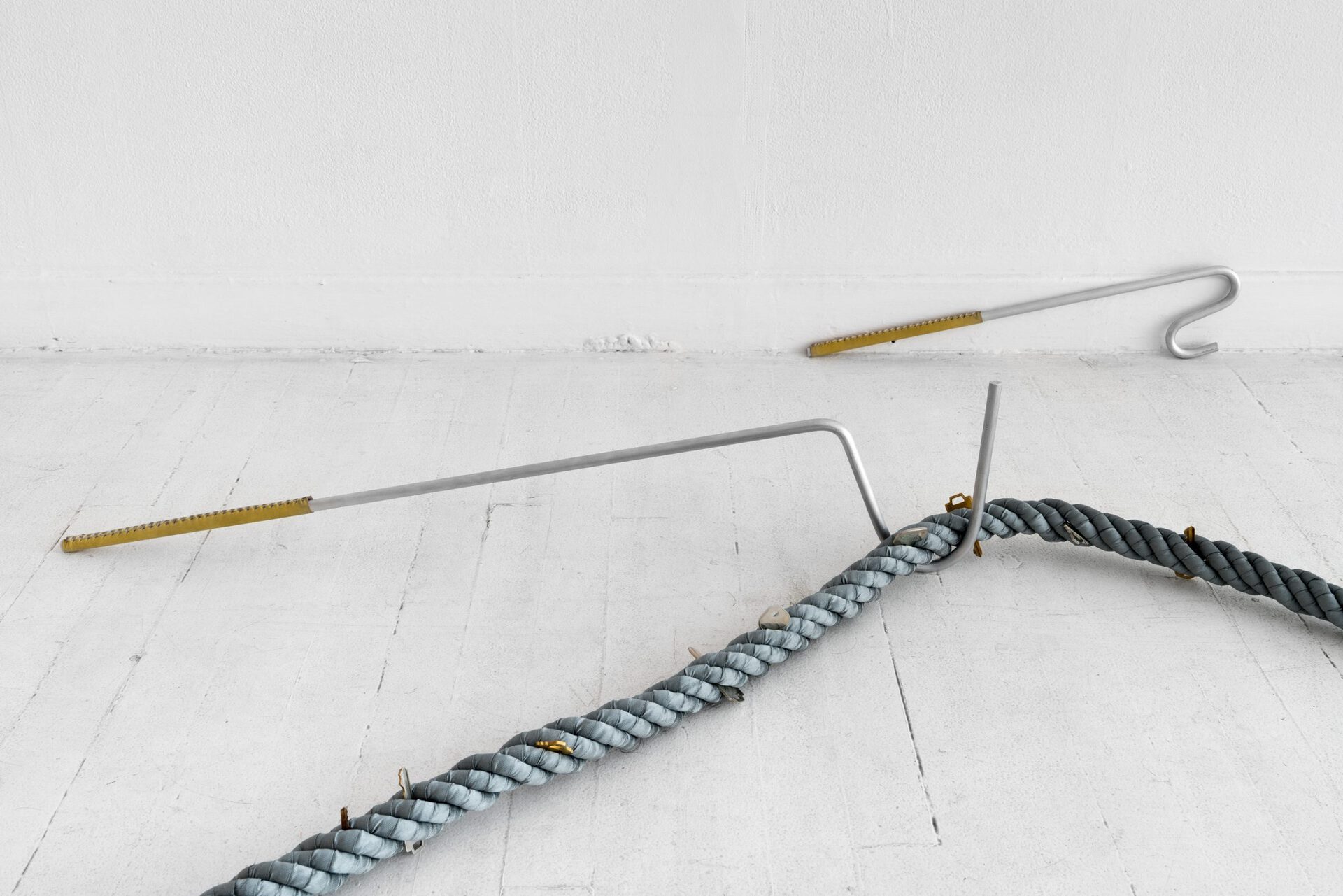 Kyle Alden Martens, Clothing/Snake Hooks, 2022, aluminum, leather, waxed cotton thread, variable dimensions