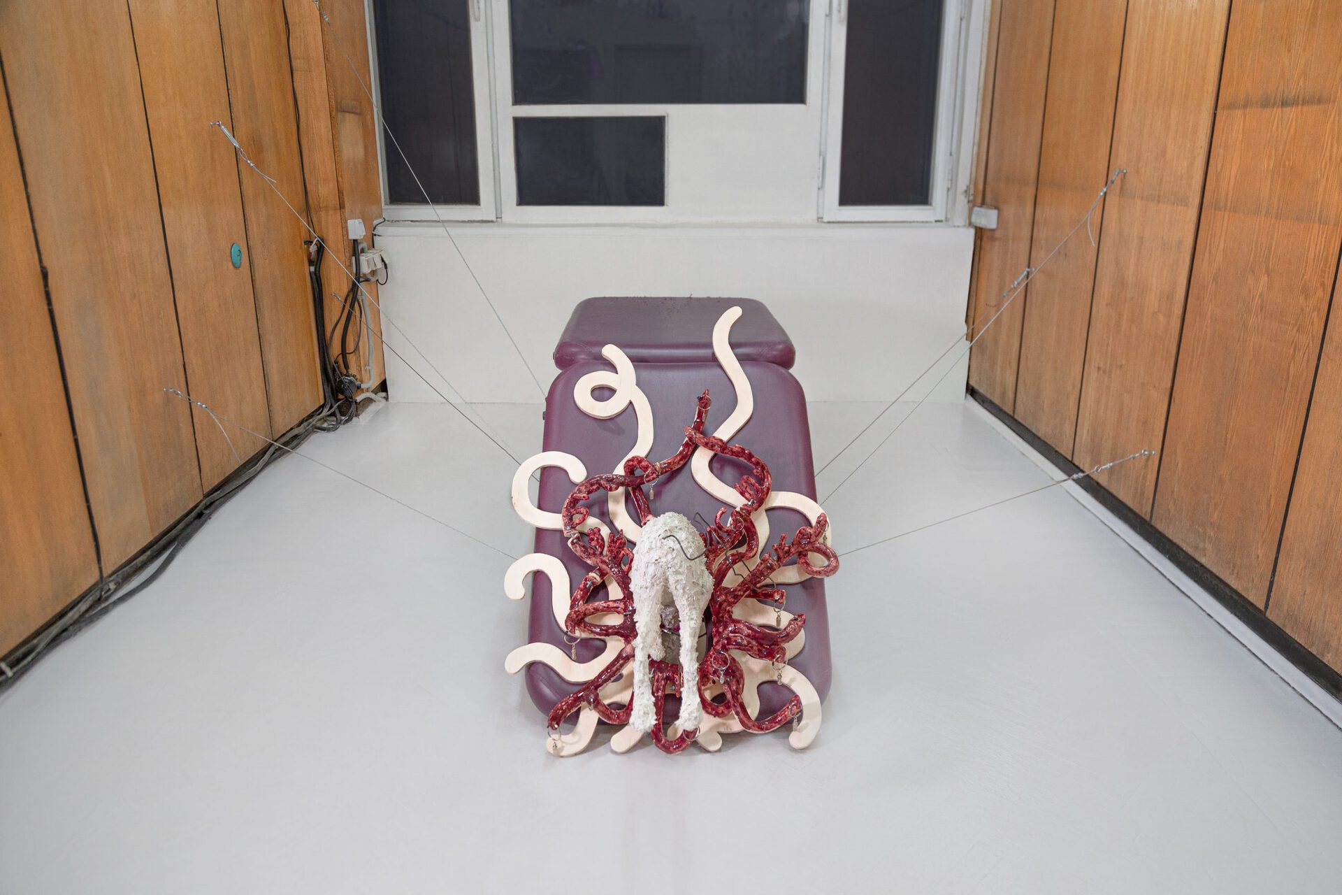 Stasia Grishina Space Dogs, 2022, massage table, plywood, glazed ceramics, styrofoam, gypsum, dog adress tags with key rings, wire, collar, steel cables, rigging; 180x70x60 cm
