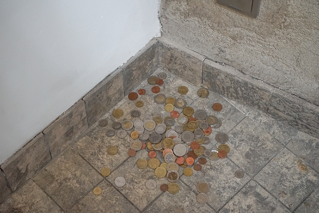 Wisrah Villefort, Set at BPA, Cologne. Nickel, 2022. A set with all coins the artist has. The curator commits to make a deposit to the artist on a total of the coins' value until the day of the exhibition's opening as agreed. (Variable materials and dim.)