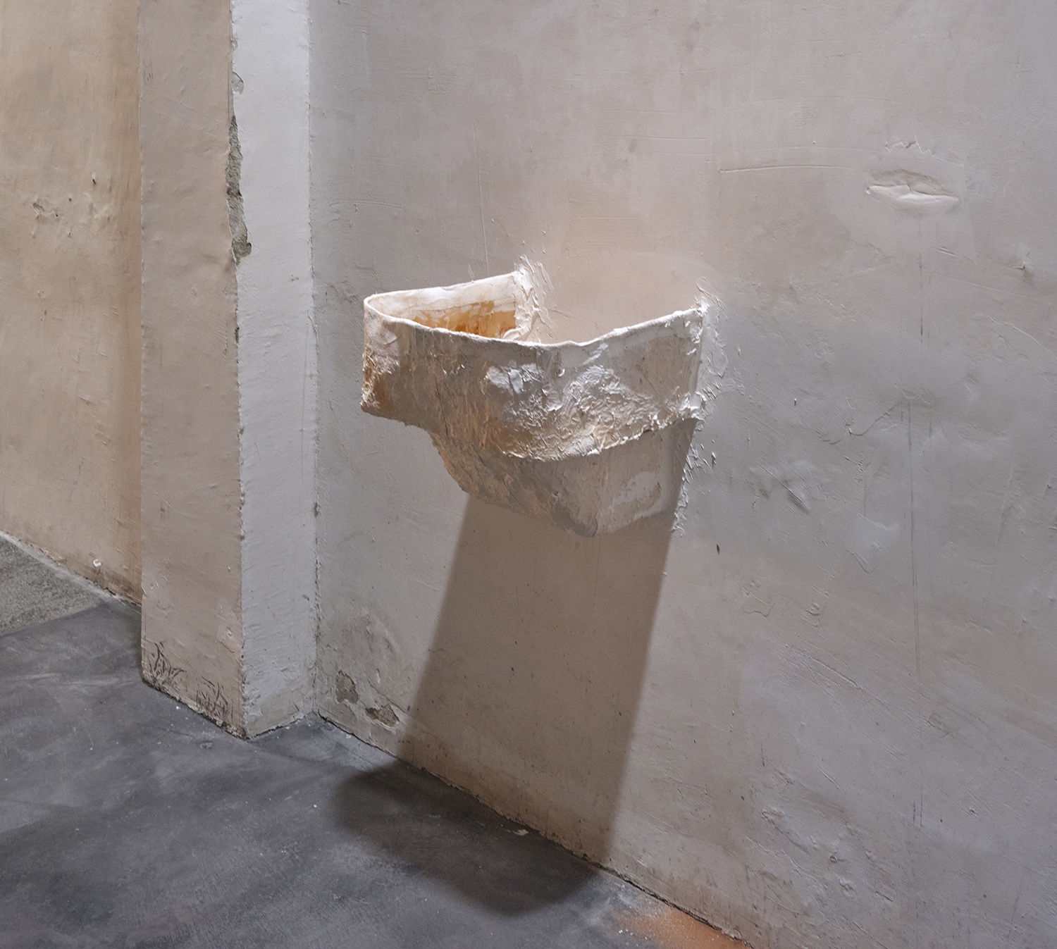 Ian Waelder. From hip to fingertip (Opel upside down), 2022. Remainder of the mould of the Opel Olympia sculpture made in collab between the artist and his father, putty on wall, iron rods, remains of the wall on the floor. 33,5 x 35,5 x 30 cm.