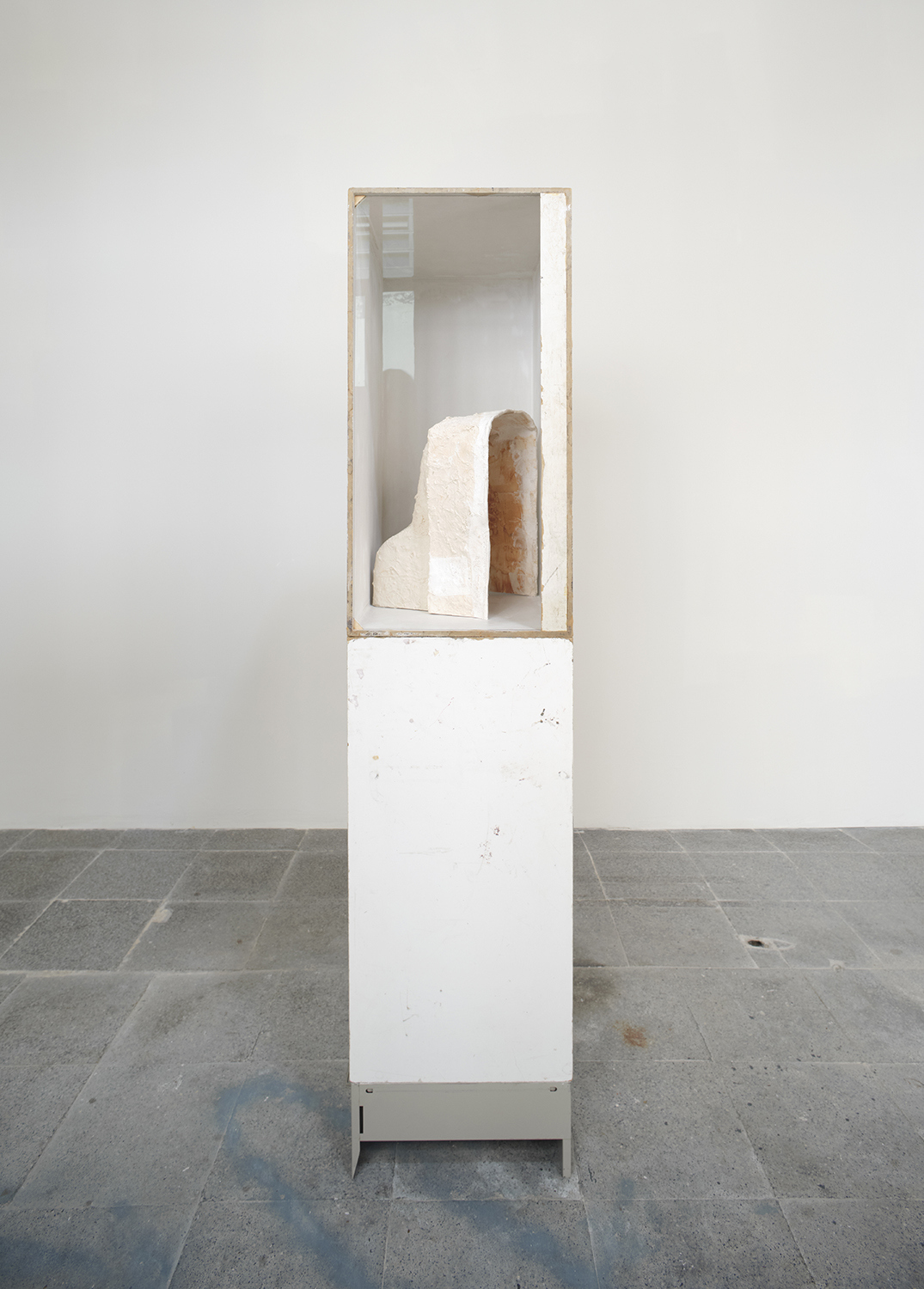 Ian Waelder. You who are the stranger (Torso), 2022. Marks of use on wood, remnants of the Opel Olympia sculpture mould made in collab between the artist and his father, plaster strips, inkjet print, museum glass, metal filing cabinets. 178 x 60 x 40 cm.