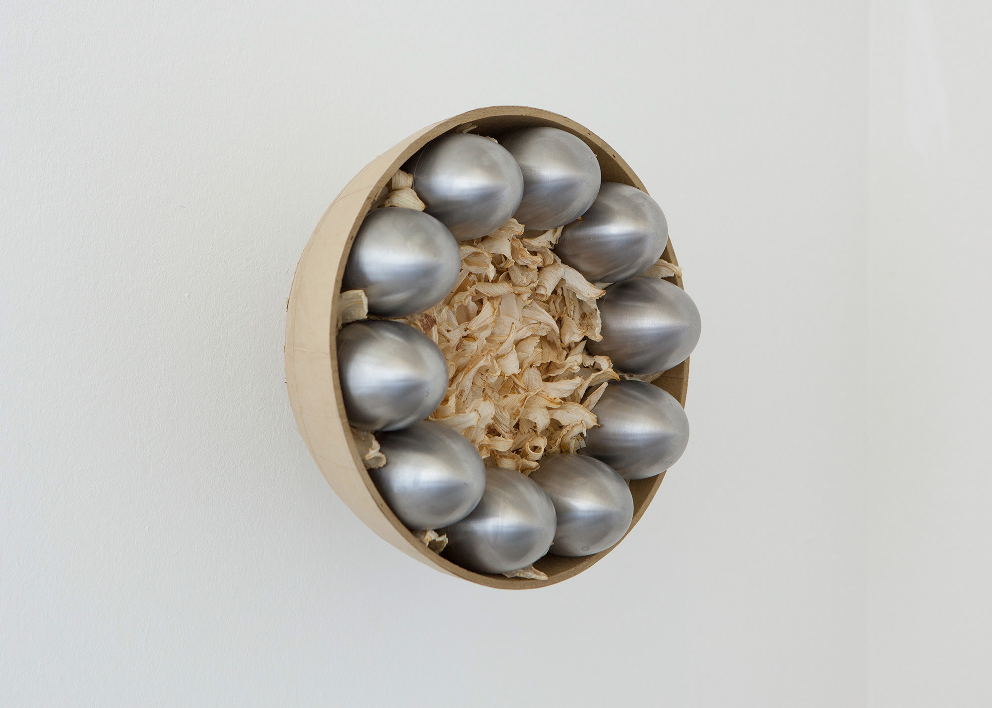Julian Siffert, in bloom, [...] out, carried [...] home, 2022, spherical firework shell, stainless steel, dried white lilies, 32 Ã— 32 Ã— 15 cm