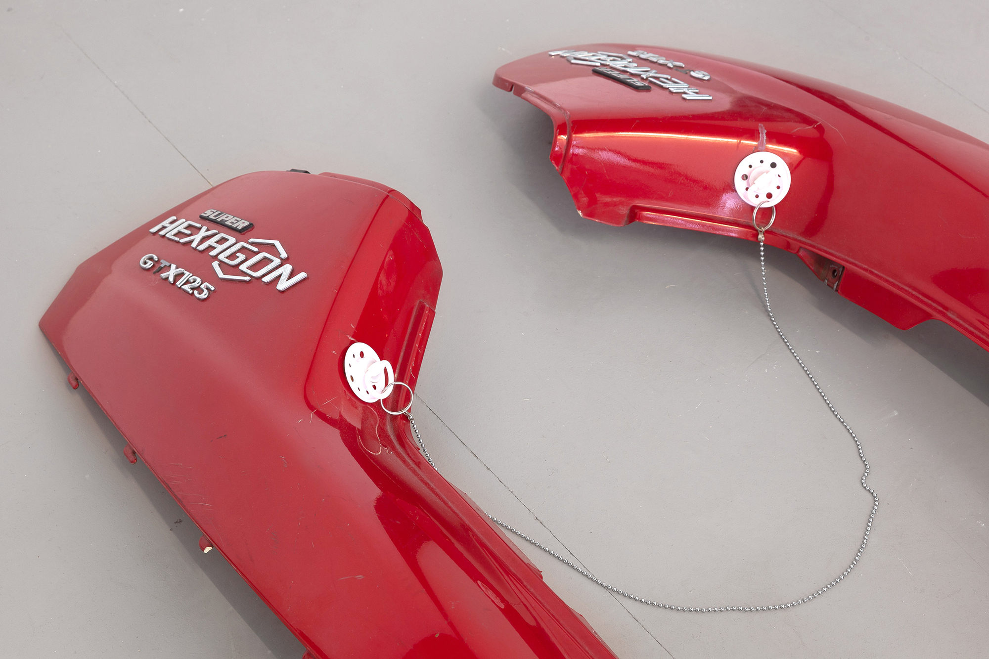 14. Paula Linke, Red Hot Lovers, scooter fairing, pacifier, ball chain, shoelaces, 2022 (Detail)
