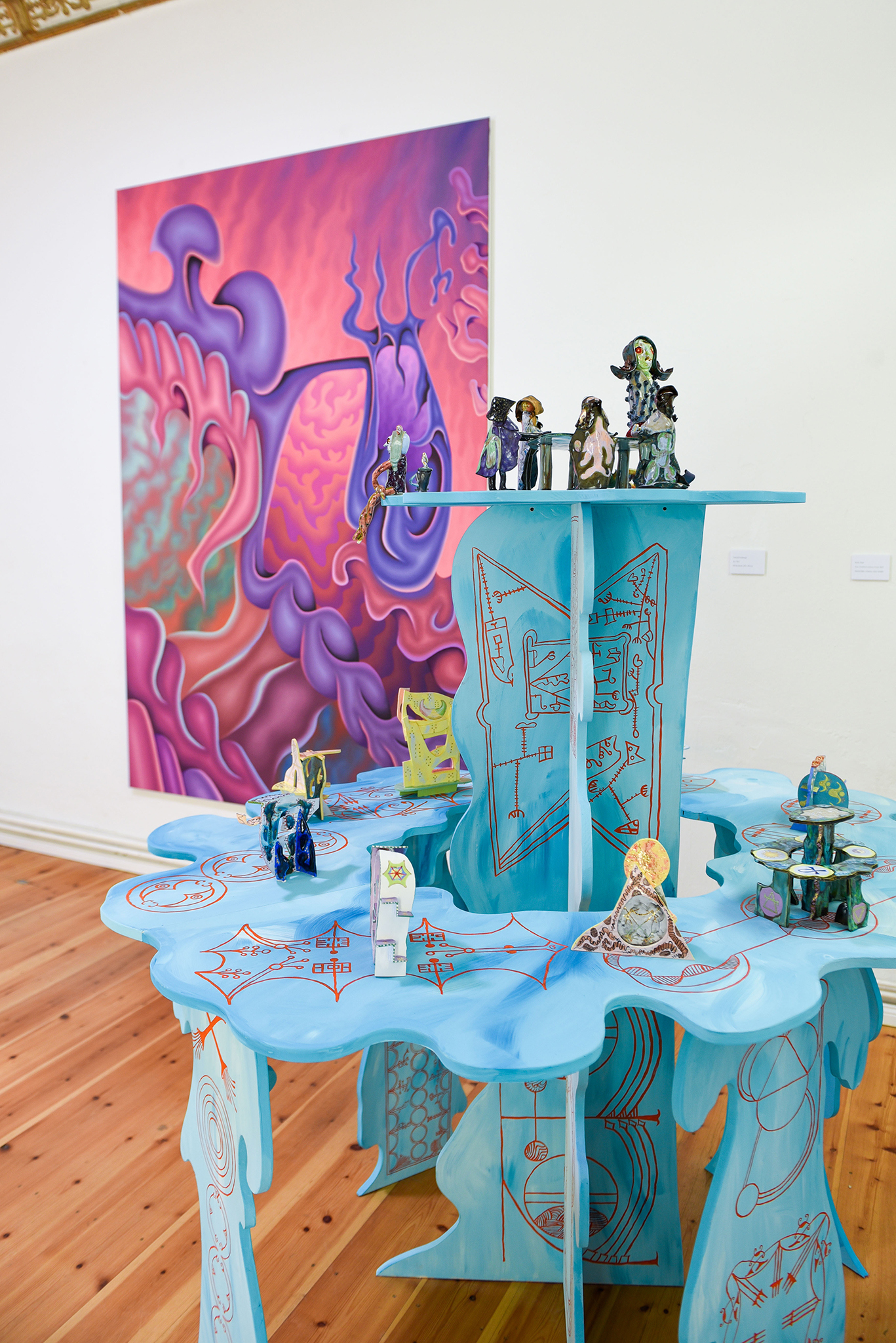 High Weirdness, Solaris Space, Berlin, 2022, Emily Hunt, Nota Flashback Tableau Vivant, 2022, painted table, ceramics & Antonia Freisburger, Superfaculag, 2022, oil on canvas, Photo: Rosanna Graf, Courtesy: the artist