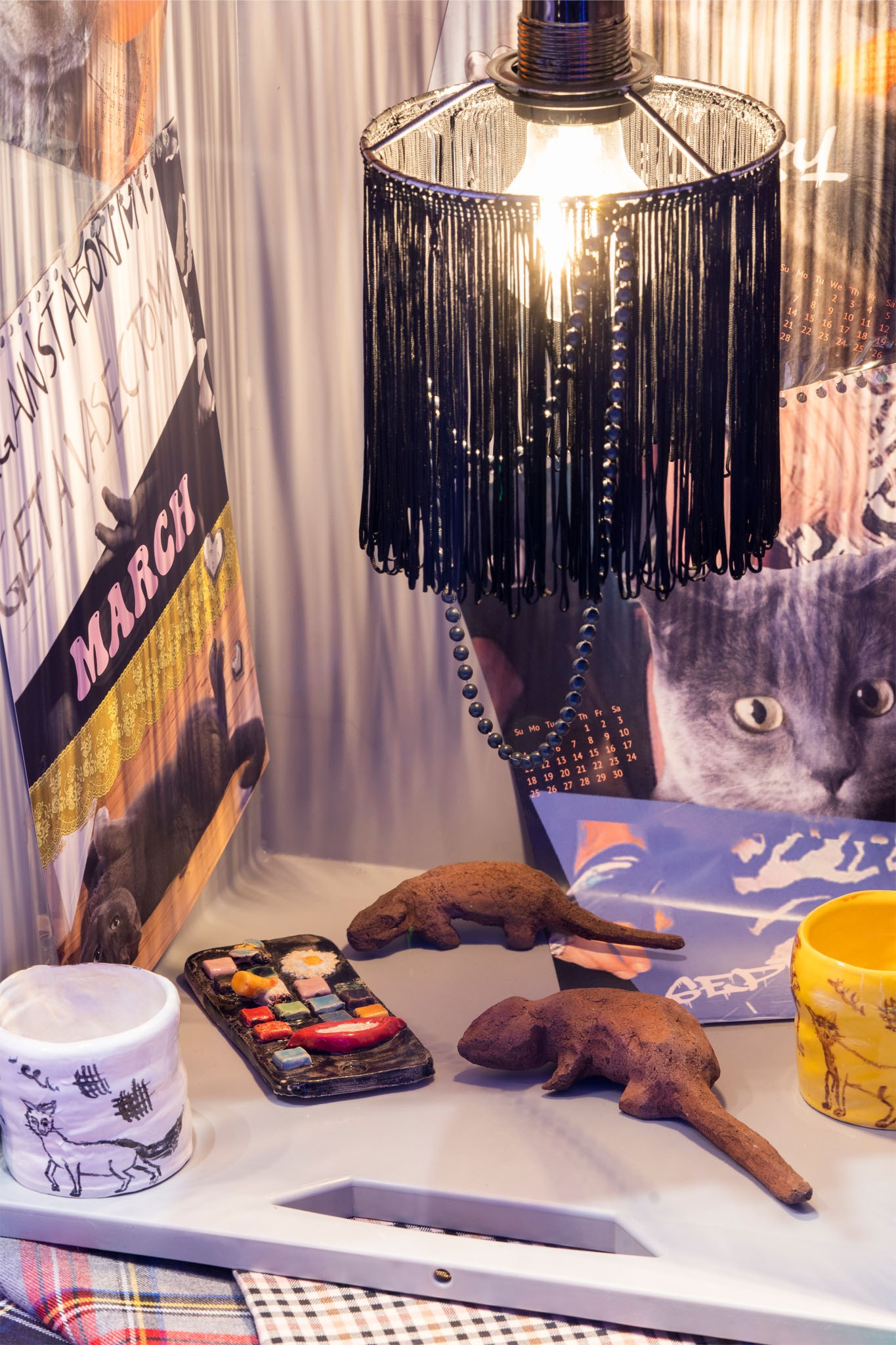Black Palm – Sonja Cvitkovic, Daily Deals, New Toni, Berlin, 2022, Installation view, cups by Isabelle Fein (glazed ceramic), lamp by Sonja Cvitkovic (textil), rats by Michaela Meise (ceramic), iPhone by Hanna Schwarz (glazed ceramic)