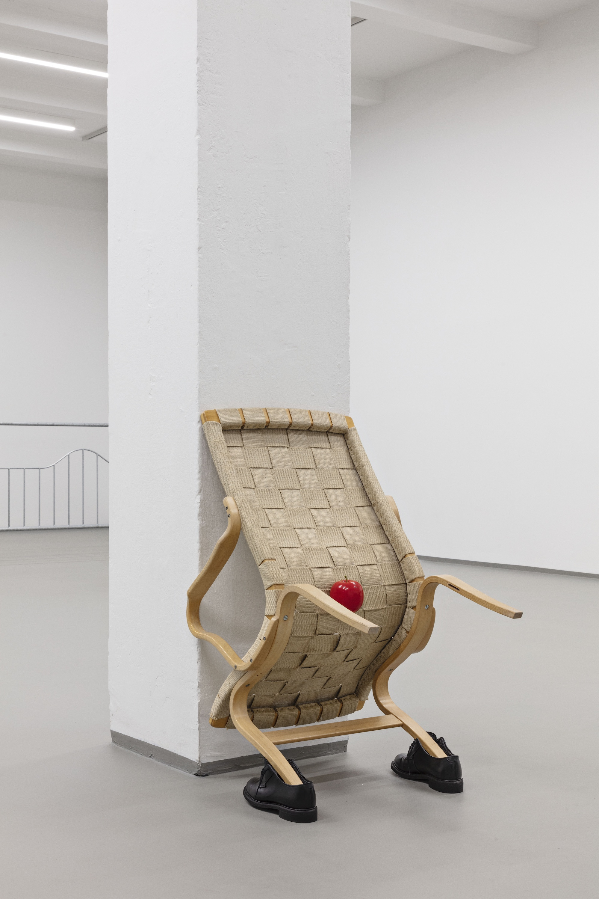 Tora Schultz: Positions, 2022. EVA Chair in bent beech by Bruno Mathsson, apple, EvaRid shoes Bates Oxford size 7.5; 95 x 70 x 50 cm. Photo: Laura Stamer