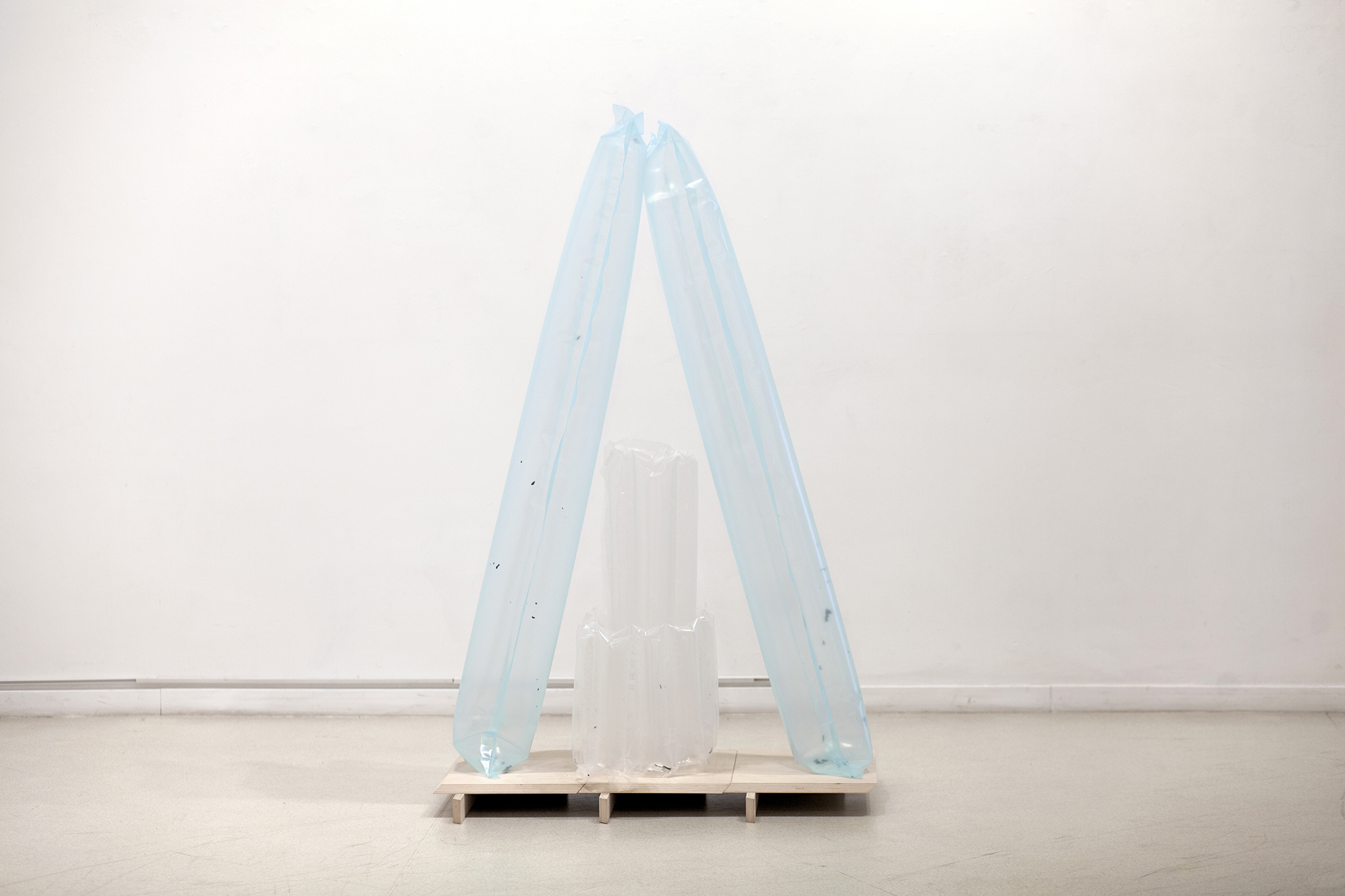 Eglė Ruibytė, Voidbag, 2022, plastic film, UV print fragments, air, wood. 150 x 90 x 40 cm. Wooden objects created by Vytautas Gečas
