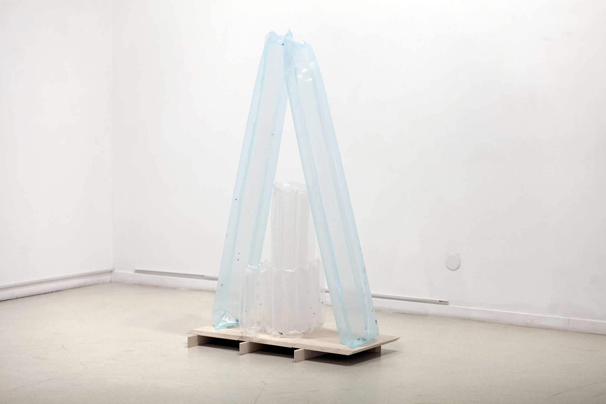Eglė Ruibytė, Voidbag, 2022, plastic film, UV print fragments, air, wood. 150 x 90 x 40 cm. Wooden objects created by Vytautas Gečas