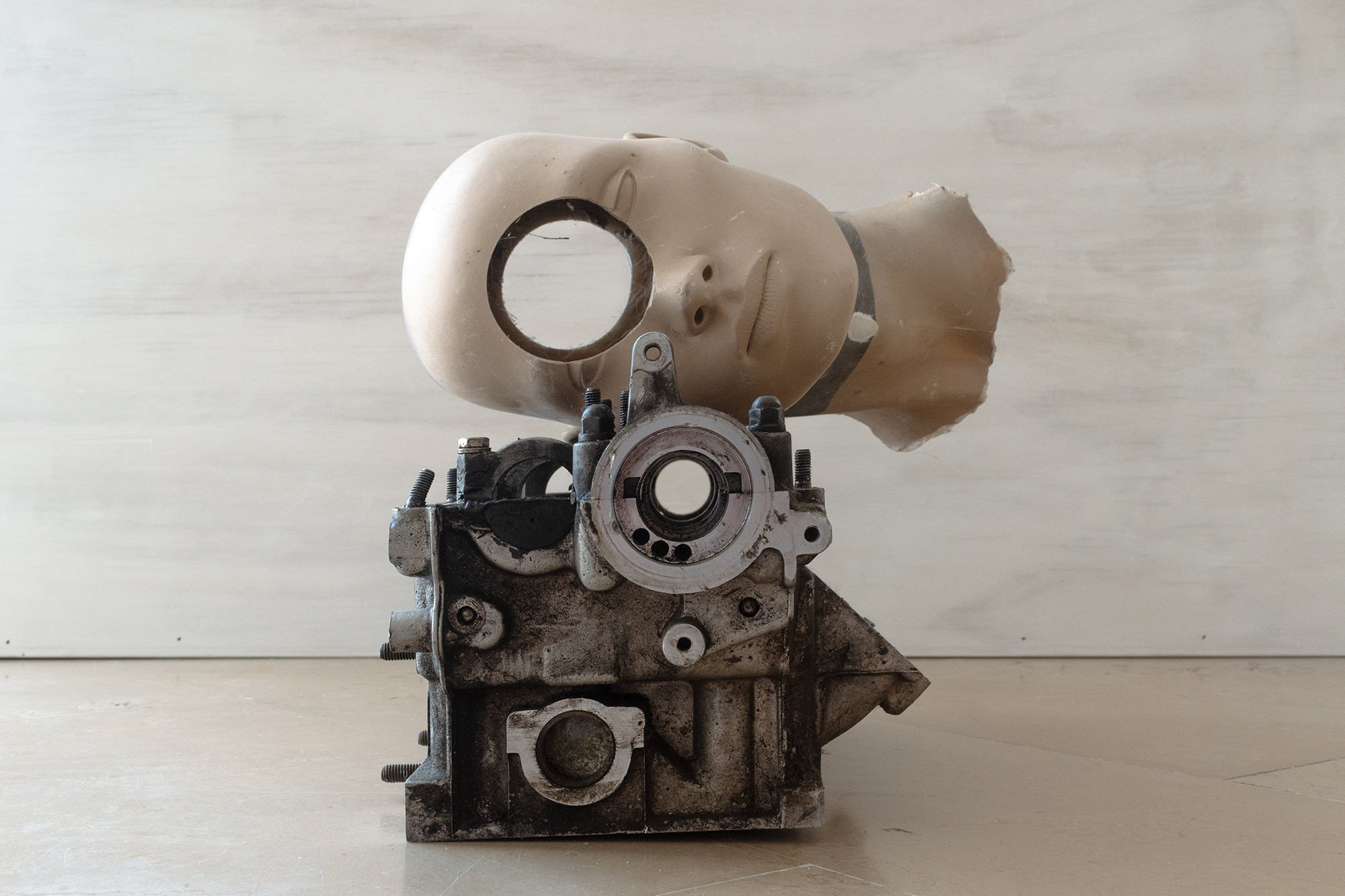 Nicolas Lamas, Cyclope, 2022, pierced mannequin head, automobile engine. 34x29x24 cm.