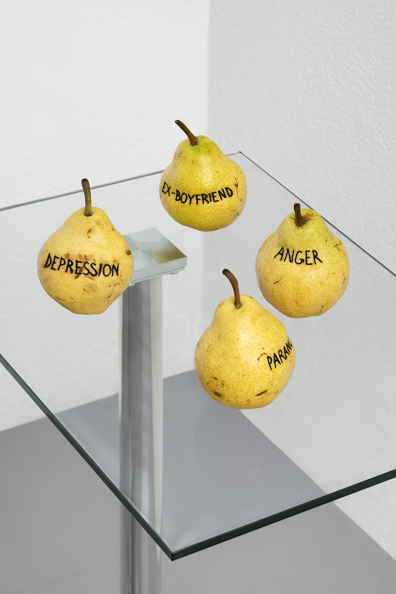 Detail of Paolo Bufalini, Anger, Ex-boyfriend, Depression, Paranoia, 2023. Glass and steel table, tattooed Kaiser pears, 75x34x50cm Courtesy of the Artist and La Rada, Locarno. Photography by Tiziano Ercoli & Riccardo Giancola
