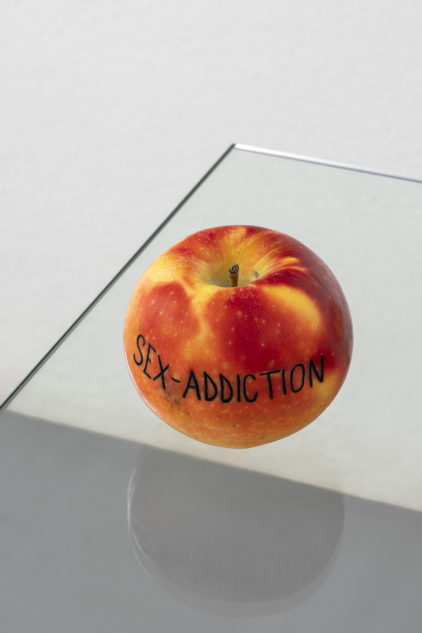 Detail of Paolo Bufalini, Self-doubt, Sex-addiction, Anorexia, 2023. Glass and steel table, tattooed Kanzi apples, 75x34x50cm. Courtesy of the Artist and La Rada, Locarno. Photography by Tiziano Ercoli & Riccardo Giancola