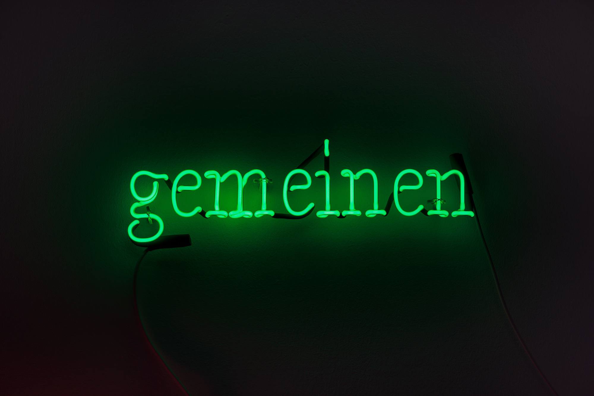 JOSEPH KOSUTH ‘K(U)#2’, 2023 Text reads: gemeinen Green neon mounted directly on the wall 10 x 42 cm © Joseph Kosuth / ARS, New York. Courtesy Christine König Galerie, Vienna.