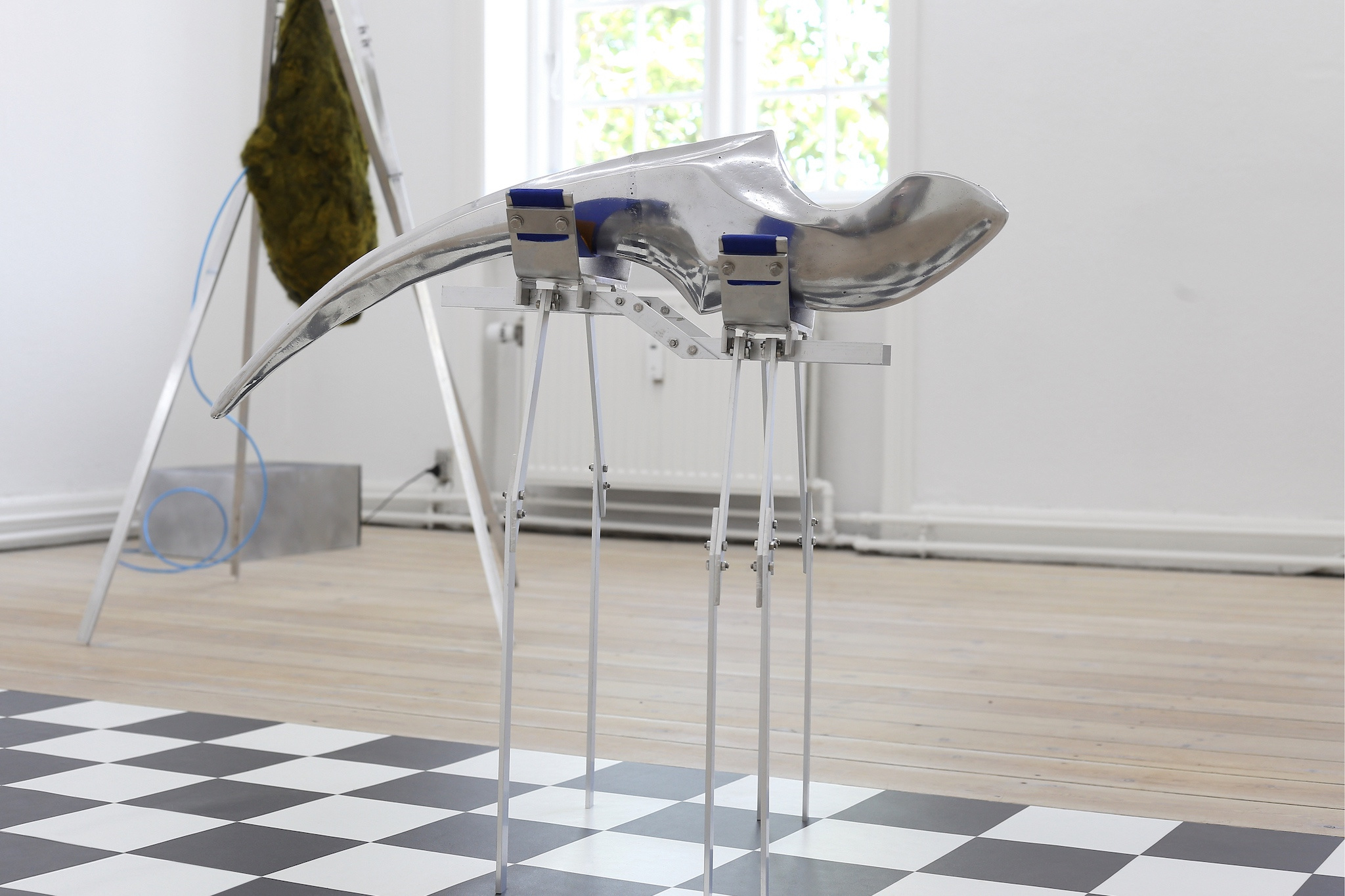 Therese Bülow, "Longing for Another Tongue", 2022. Polished aluminium, stainless steel, belt, wool dyed with dyers chamomile, 62.0 x 80.0 x 36.0 cm