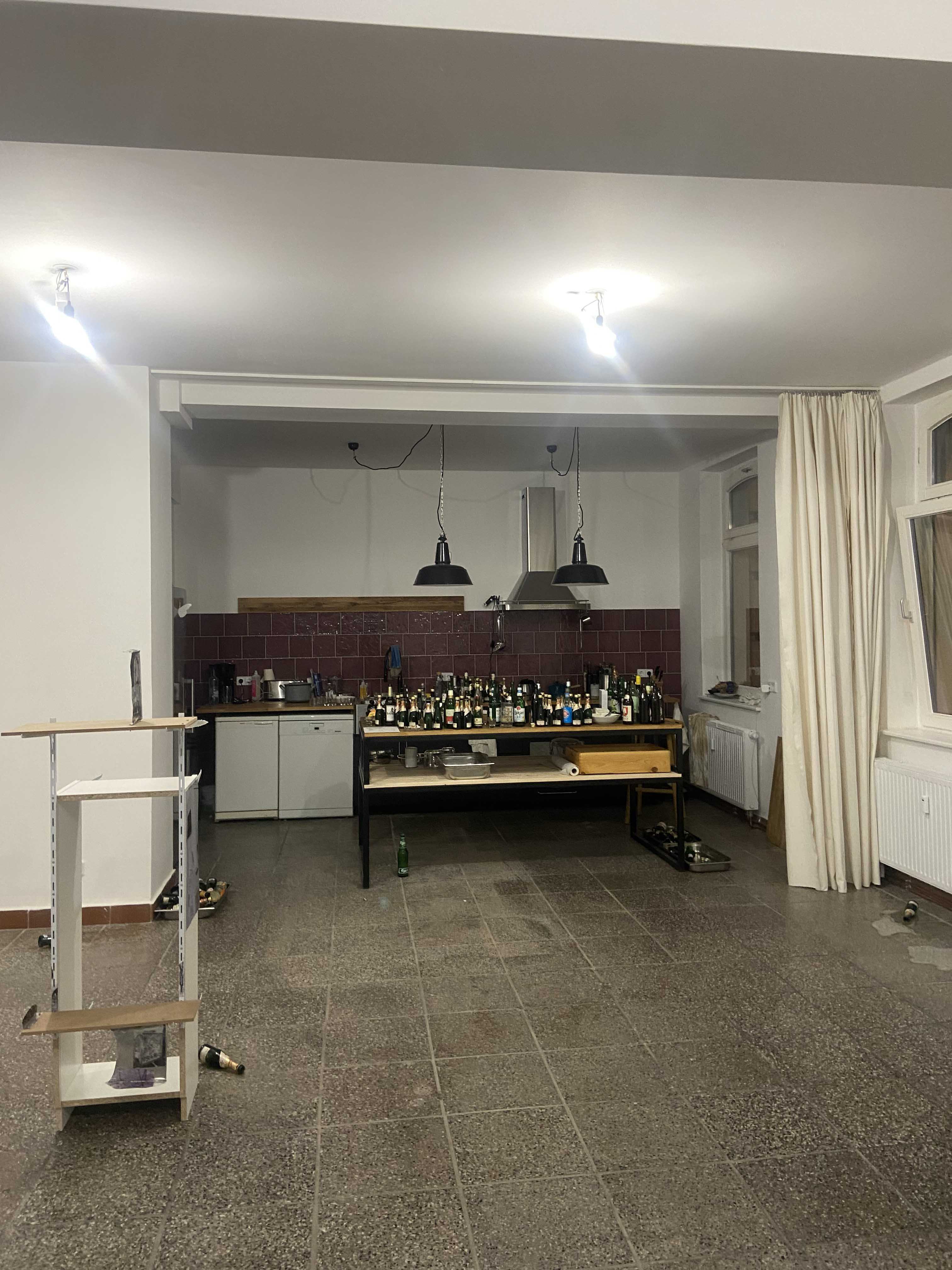 Exhibition view after the opening with the kitchen and many empty bottles of Henkell Piccolo Trocken