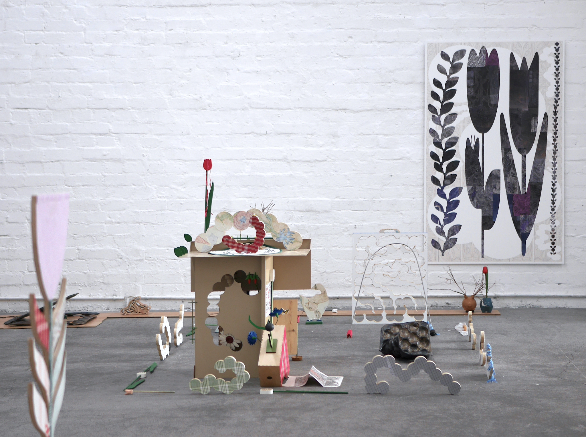 The dawn of everything; Series of cutout caterpillars: furniture-board, textile / Assemblage: painted steel, wood, furniture- board, textile, wooden flowers, drawing on a map and lotto ticket, miscellaneous objects, 2023
