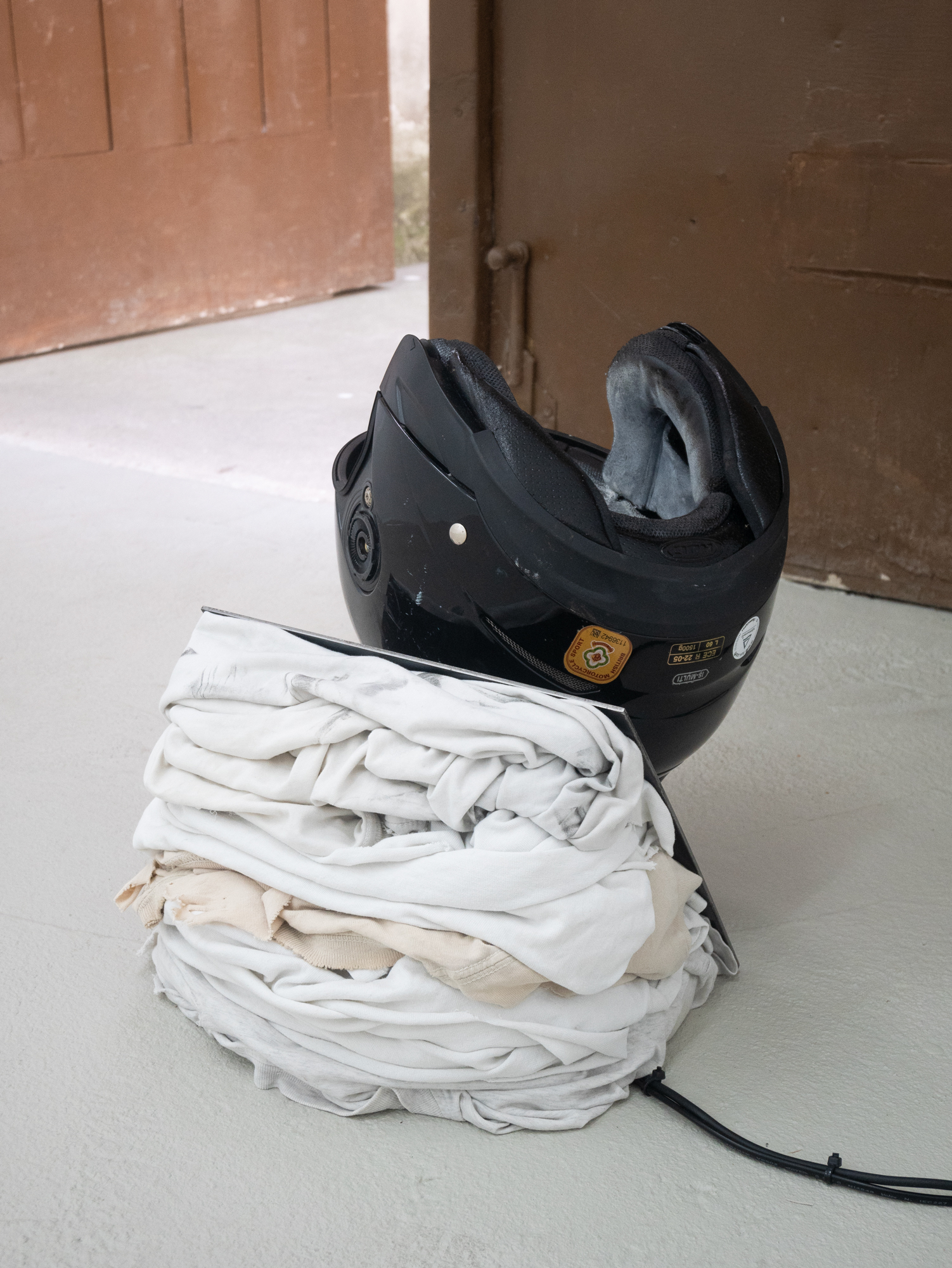 Clemens Tschurtschenthaler; fly on the wall (next doors drama); 2023; helmet, gesso, spray paint, waxed steel, textiles, media player, speaker, sound composition (09:44 min.); 39 x 31 x 41 cm