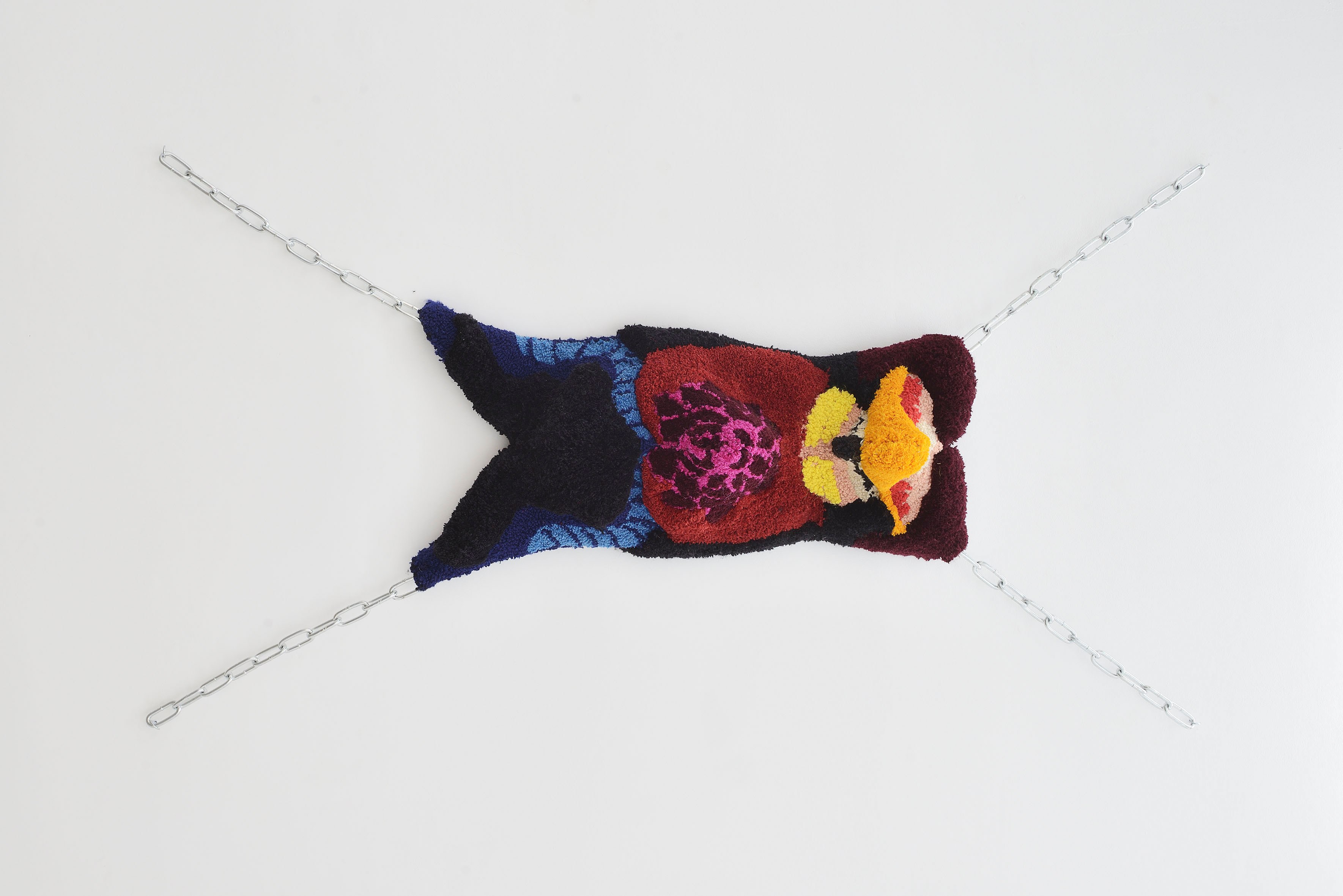 Anna Perach, The Rack, 2023, tufted Axminster yarn, metal chains, faux leather, 195 x 104 x 30 cm