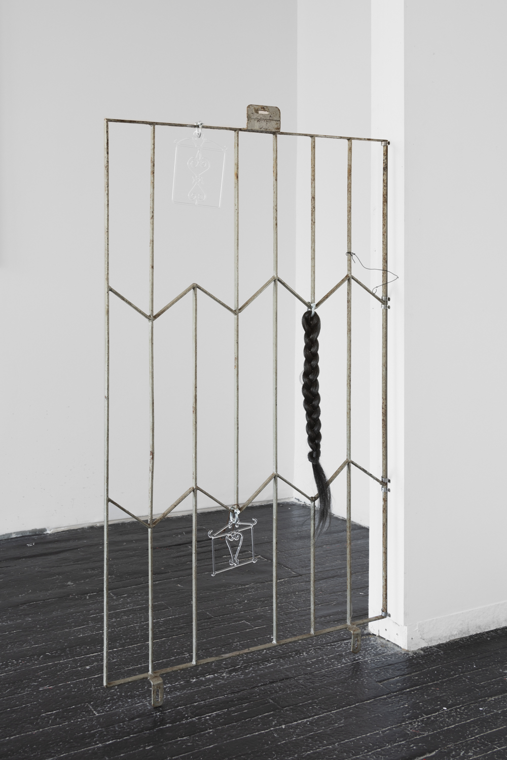 Installation shot, Adrienne Greenblatt Sheol i (2023) and Sheol ii (2023) and braided hair piece on antique steel fence