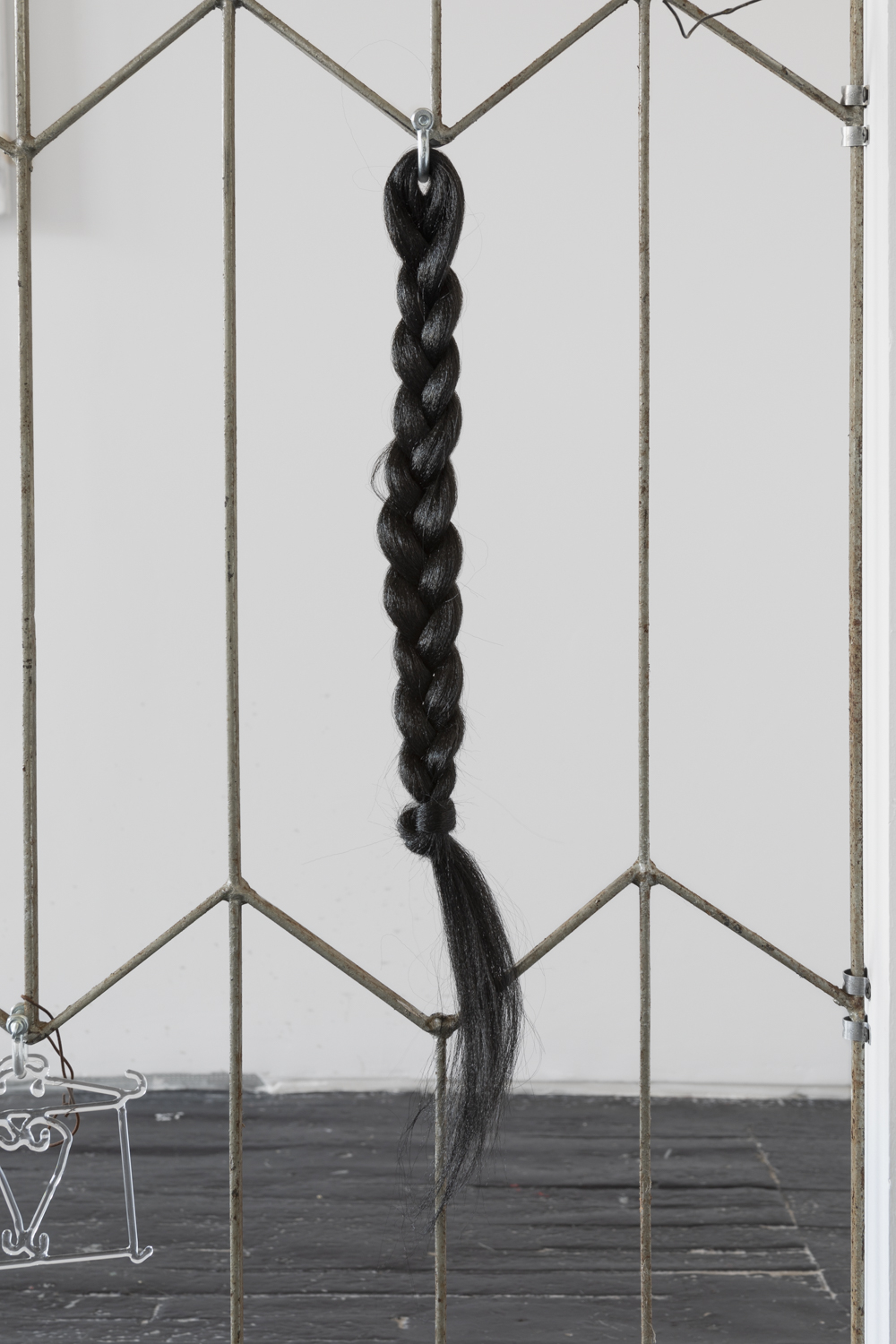Adrienne Greenblatt, detail shot of Sheol ii (2023) and braided hair piece on antique steel fence