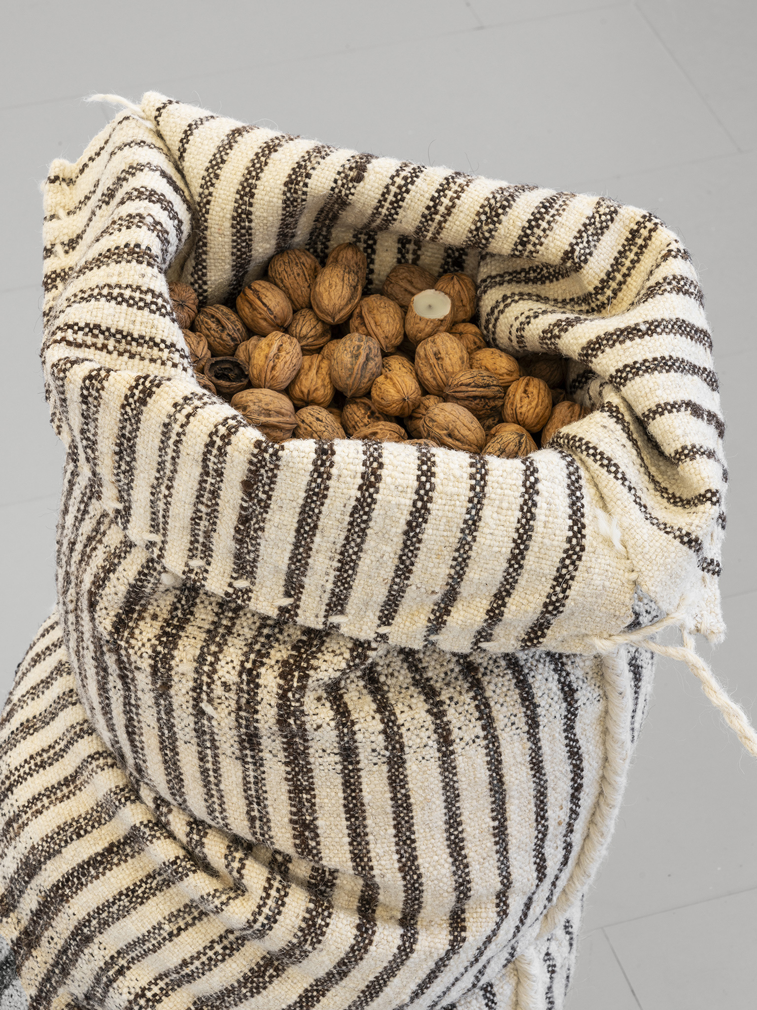 Exhibition View «UNSEEN RECONSTRUCTIONS; view on Vladimir Miljević, Transboundary Waters (Fruits of Labour),coastal wool bags with walnuts and metallic buoys, 2023» at La rada / Photo: Riccardo Giancola /Courtesy : the artists and La rada