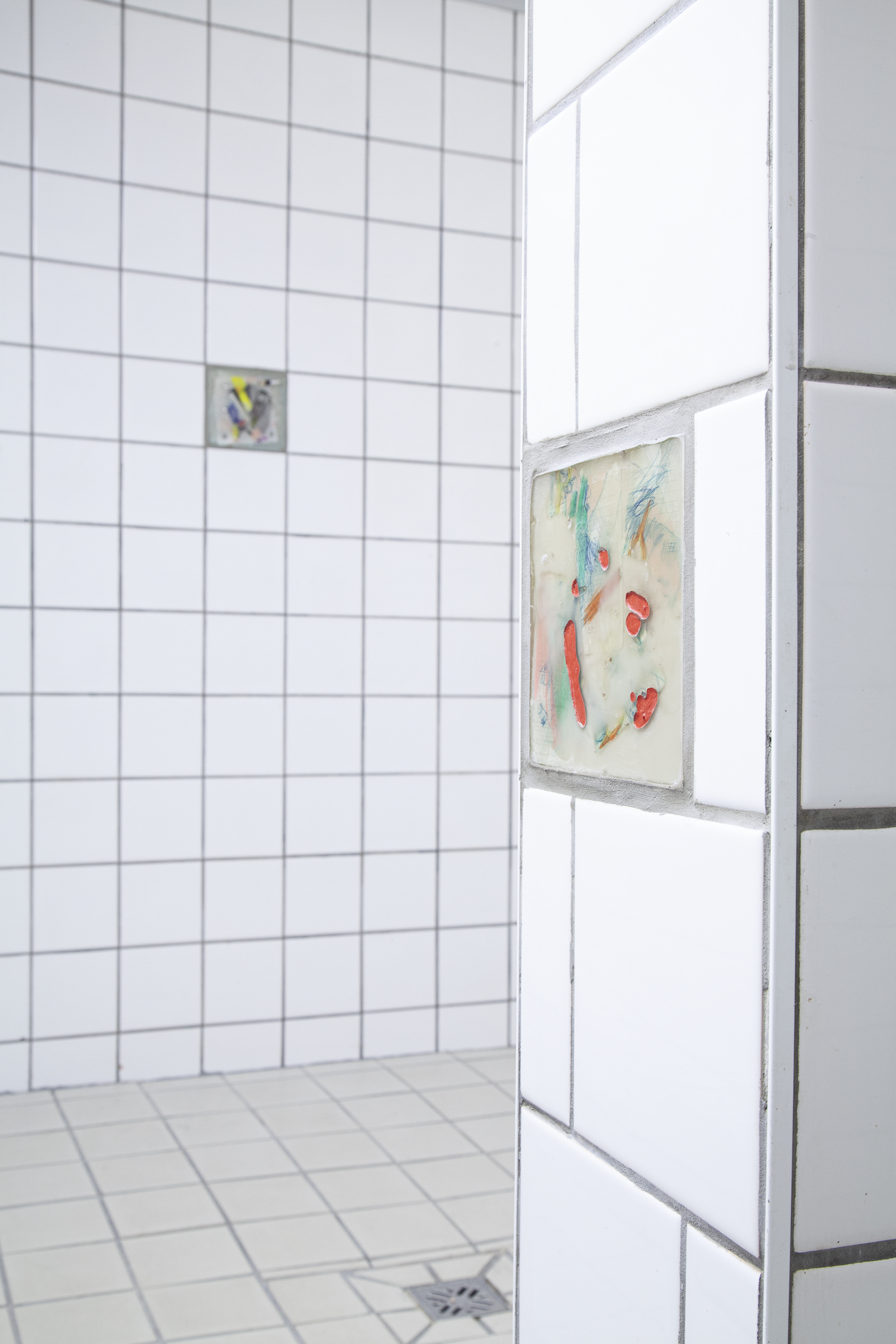 in the shower room: Leo Lunger, âtiles in the wallâ, 13 tiles, 15 x 15 cm, epoxy, mixed media, 2023