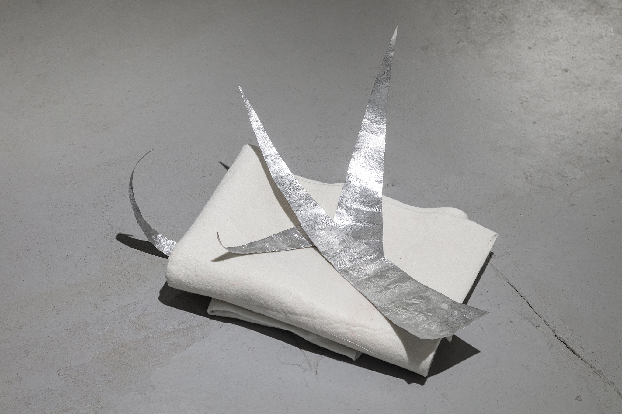 Untitled (I would like to know why), white felt, hand-hammered aluminium, 2023