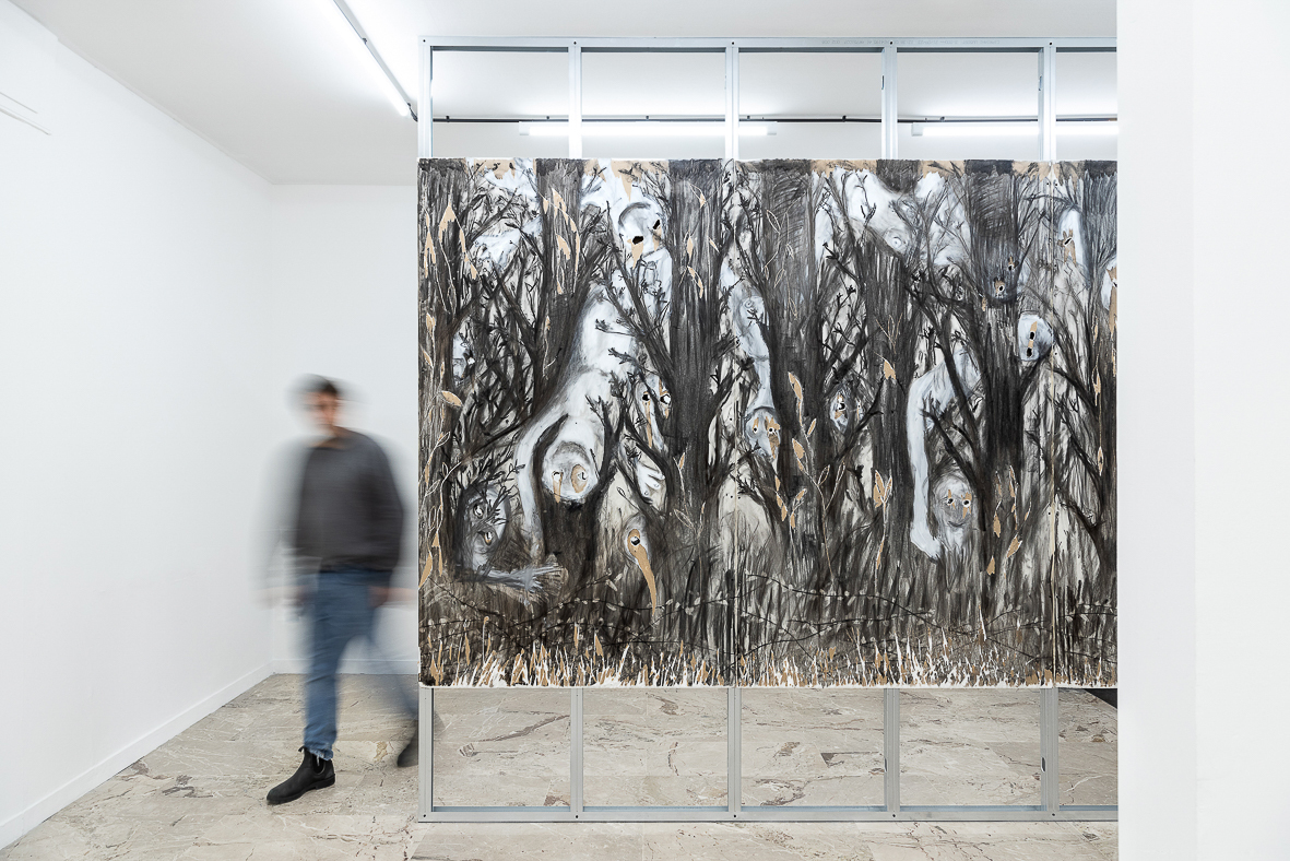 Sebastiano Sofia (Verona, 1986) next to the work “Gli alberi muoiono in piedi” (The trees die standing). 2023