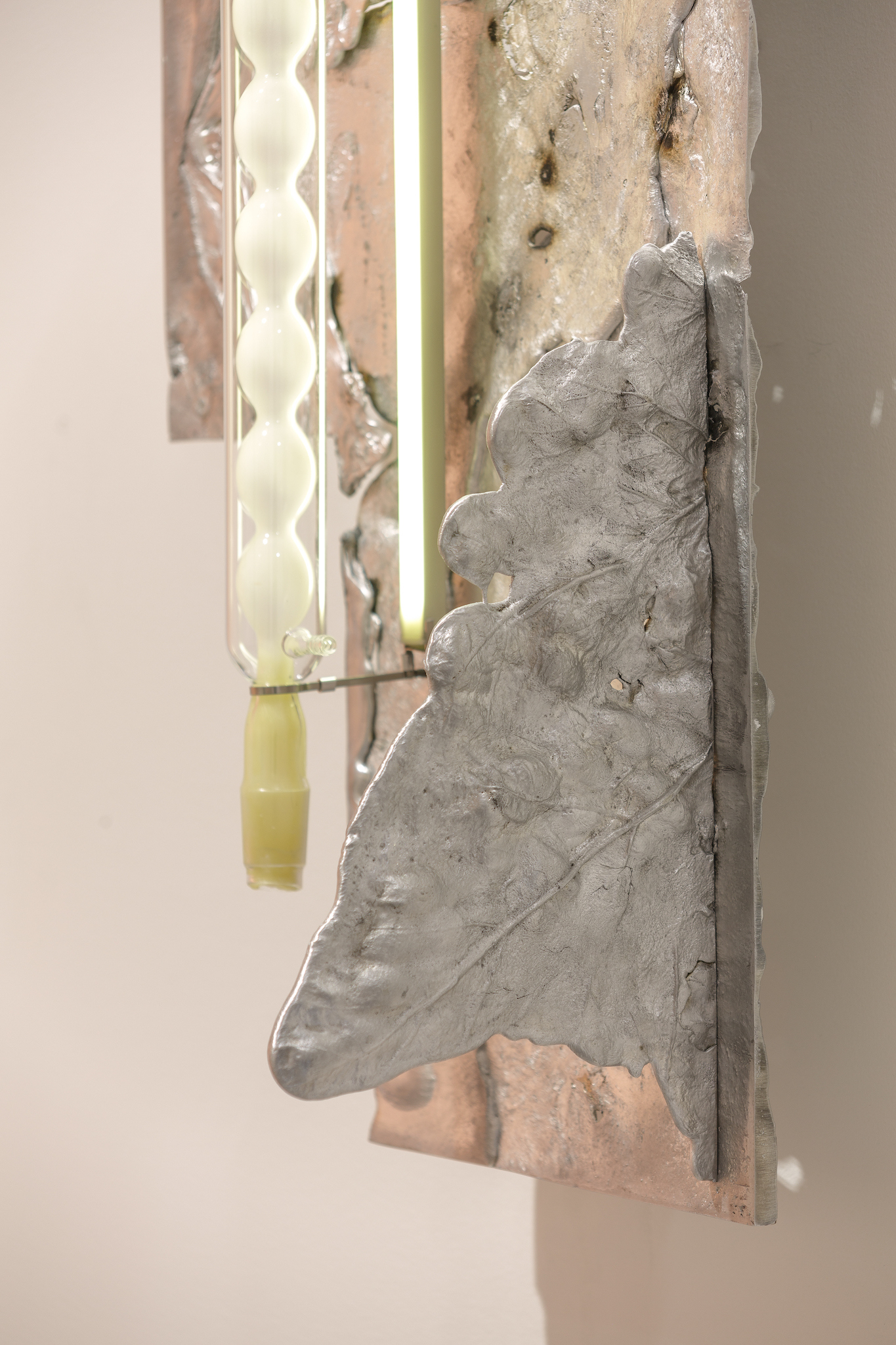 Pakui Hardware, Heat Treated, 2024. Casted aluminium, laboratory glass, bees wax, stainless steel, LED light, 107x42,5x26 cm