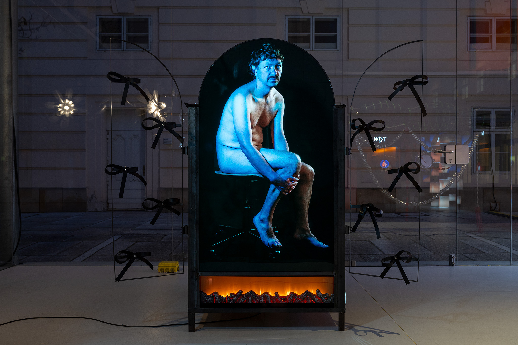 Heti P. 2 (Kamin piece), 2024  Steel, foil laminated on Plexiglas, wood, rubber, LED stripes, industrial aluminum foil, string of lights, electric fireplace, 100 x 154,5 x width variable