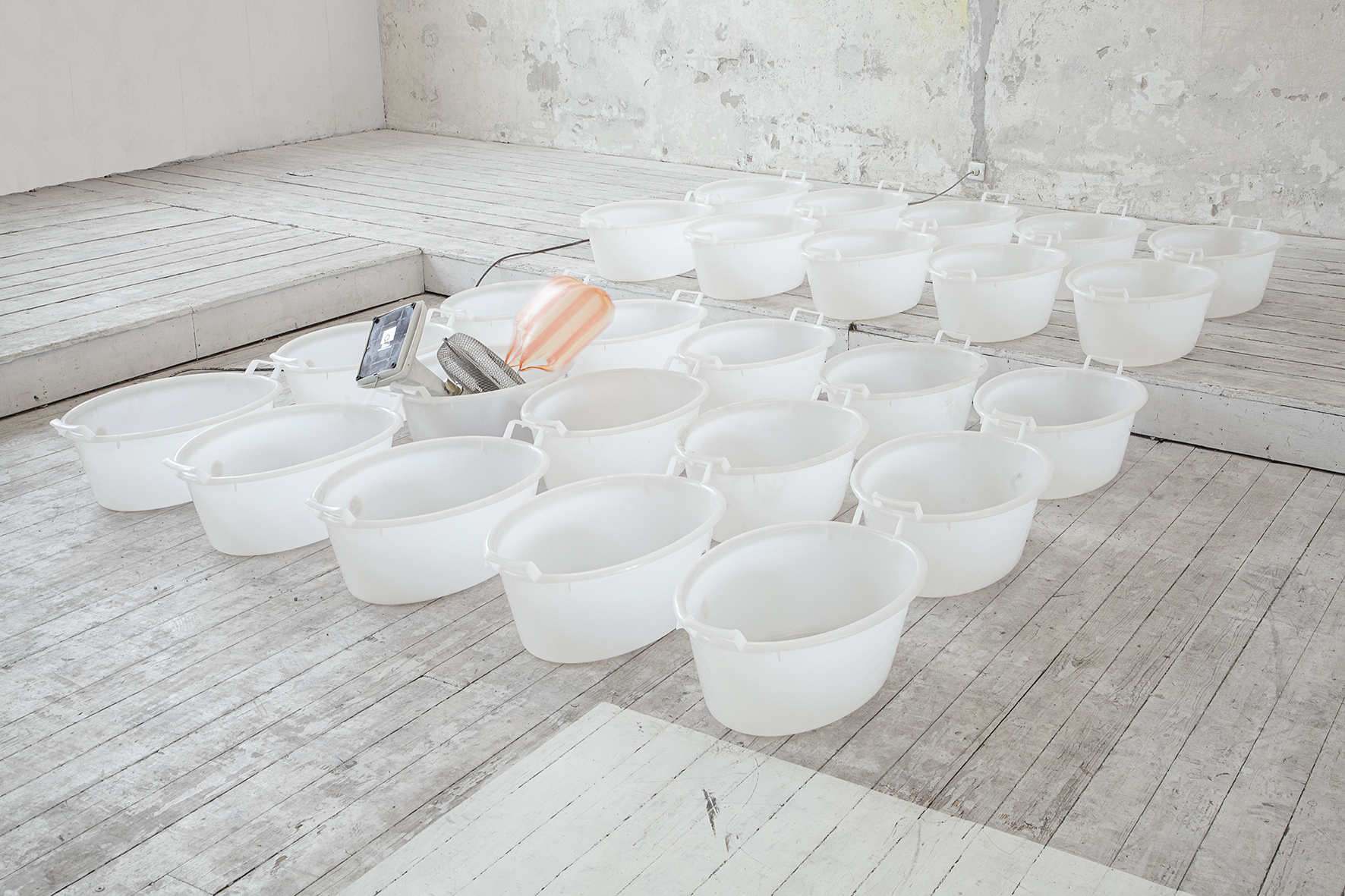 Raphael Pohl; bright day, dark sky, people floating, stars up high; 33 plastic pools, one ventilator, one extension cable, 40 liters of water, two glasses, one plastic bag; various dimensions; 2024