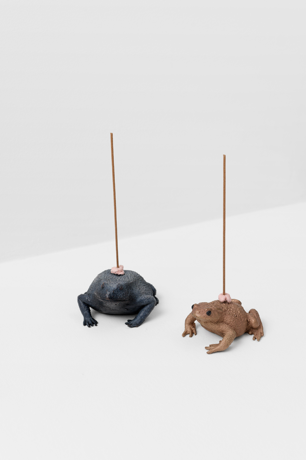 Hamish Pearch, The only way in is outside (blue toad), 2024 & The only way out is inside (brown toad), 2024, bronze, patina, paint, incense, smoke, 19 x 10 x 8 cm & 19 x 8 x 7 cm, edition of 10 (each) 