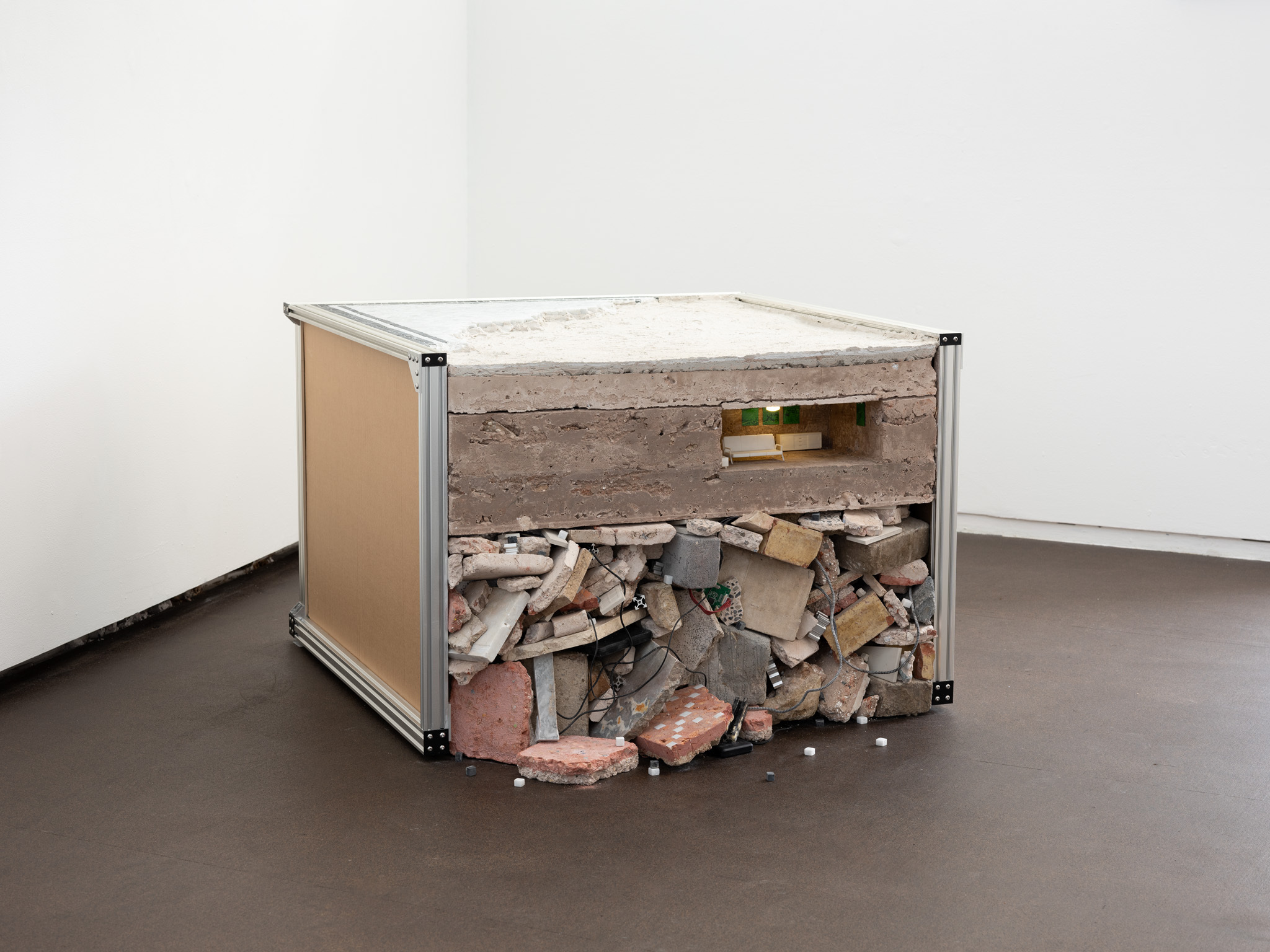 Perfect Time Compression, 2024.  Stones, recycled artworks, lime mortar, marble mosaic, aluminium v slot, cardboard, 3D printed furniture, light 100 x 100 x 60cm