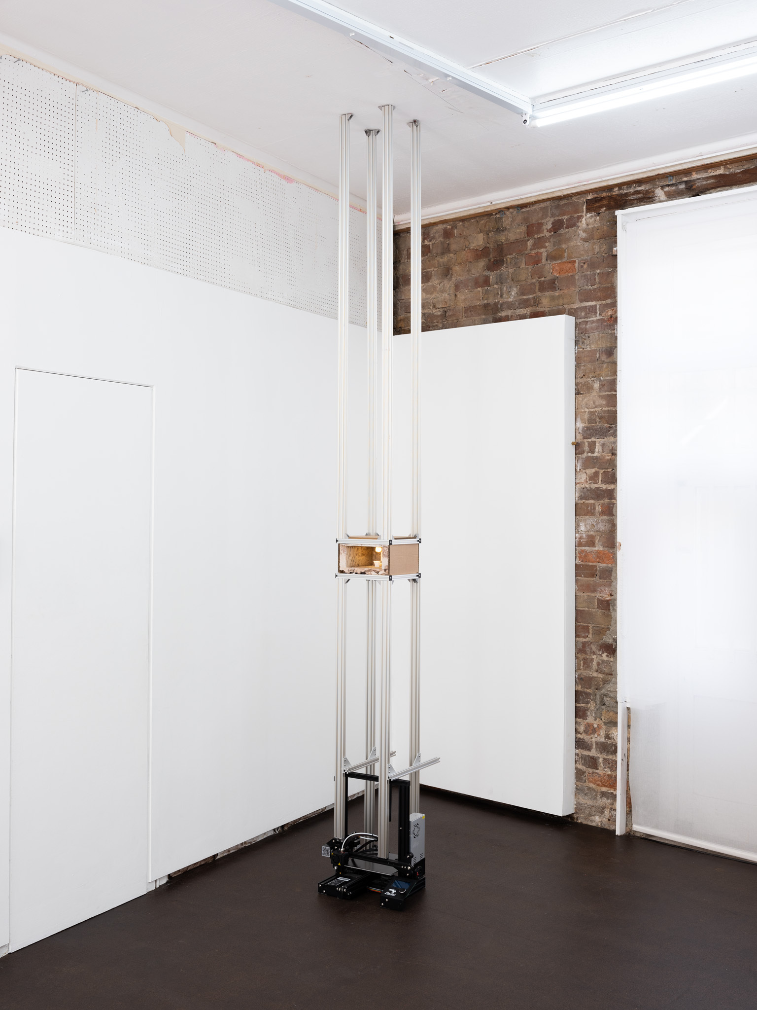 That’s the world I’m going to send you to!, 2024 3D printer, lime mortar, aluminium v slot, cardboard, 3D printed furniture, light 25 x 27 x 360cm (height variable)