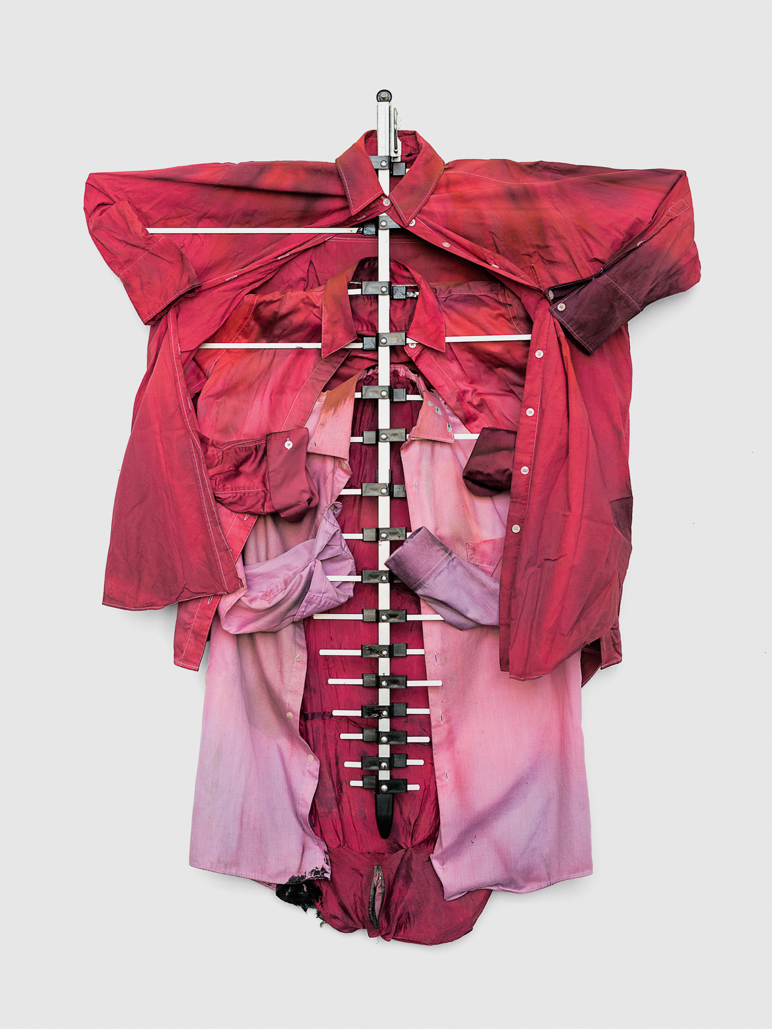 Tahir Karmali, Pull me apart and I’ll show grace, 2024, Second-hand cotton shirts, fabric dye, oxidized iron dye from guns, plastic, aluminum, safety pin, and liquid rubber, 35.5 x 52 x 4.5 inches / 92.7 x 132.1 x 11.5 cm