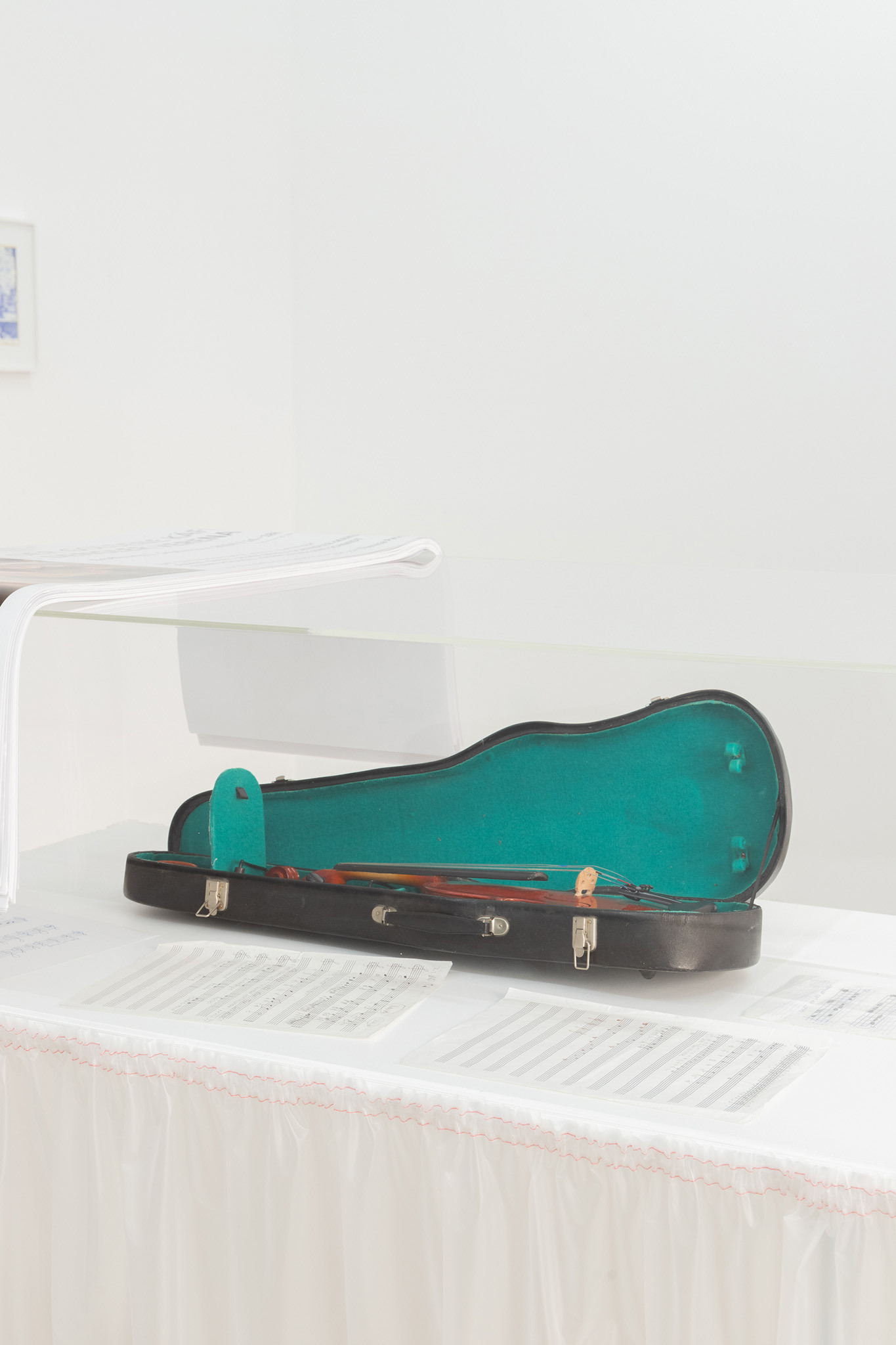 Verena Dengler, „Erste Geige”, sheet music composition Verena Dengler, early 1980s, sheet music, dimensions variable, violin in case with accessories, customized plate, plexiglass, plastic fabric, 111 x 122 x 71 cm, 2024