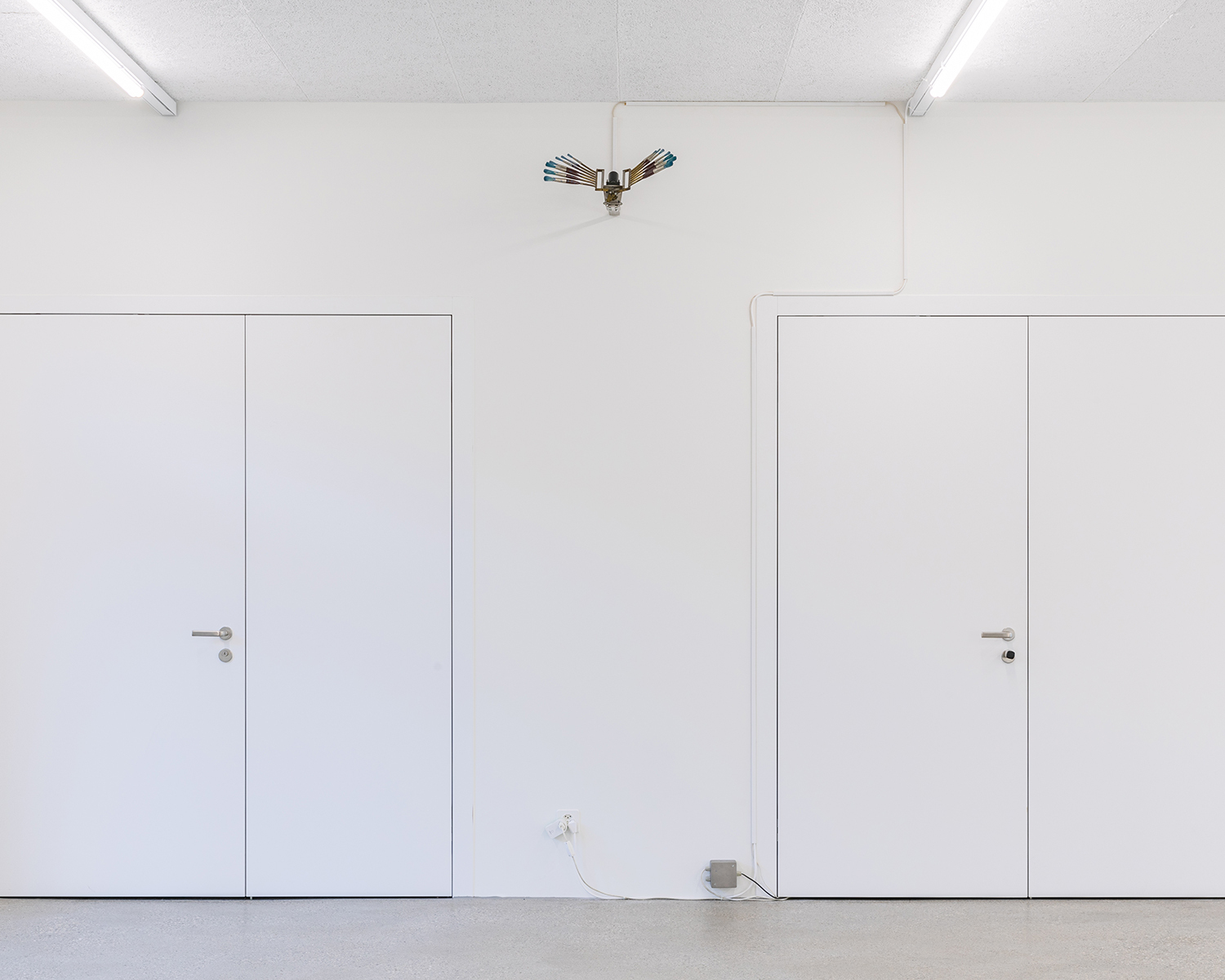 Exhibition view; Rebecca Horn, Brush Machine, 1989, 14 brushes, metal, motor, 12v transformer, mechanical timer, 30 x 45 x 33cm, CALM - Centre d'Art La Meute, 2024/Photo: Théo Dufloo/Courtesy of the artist, collection AL'H and CALM.