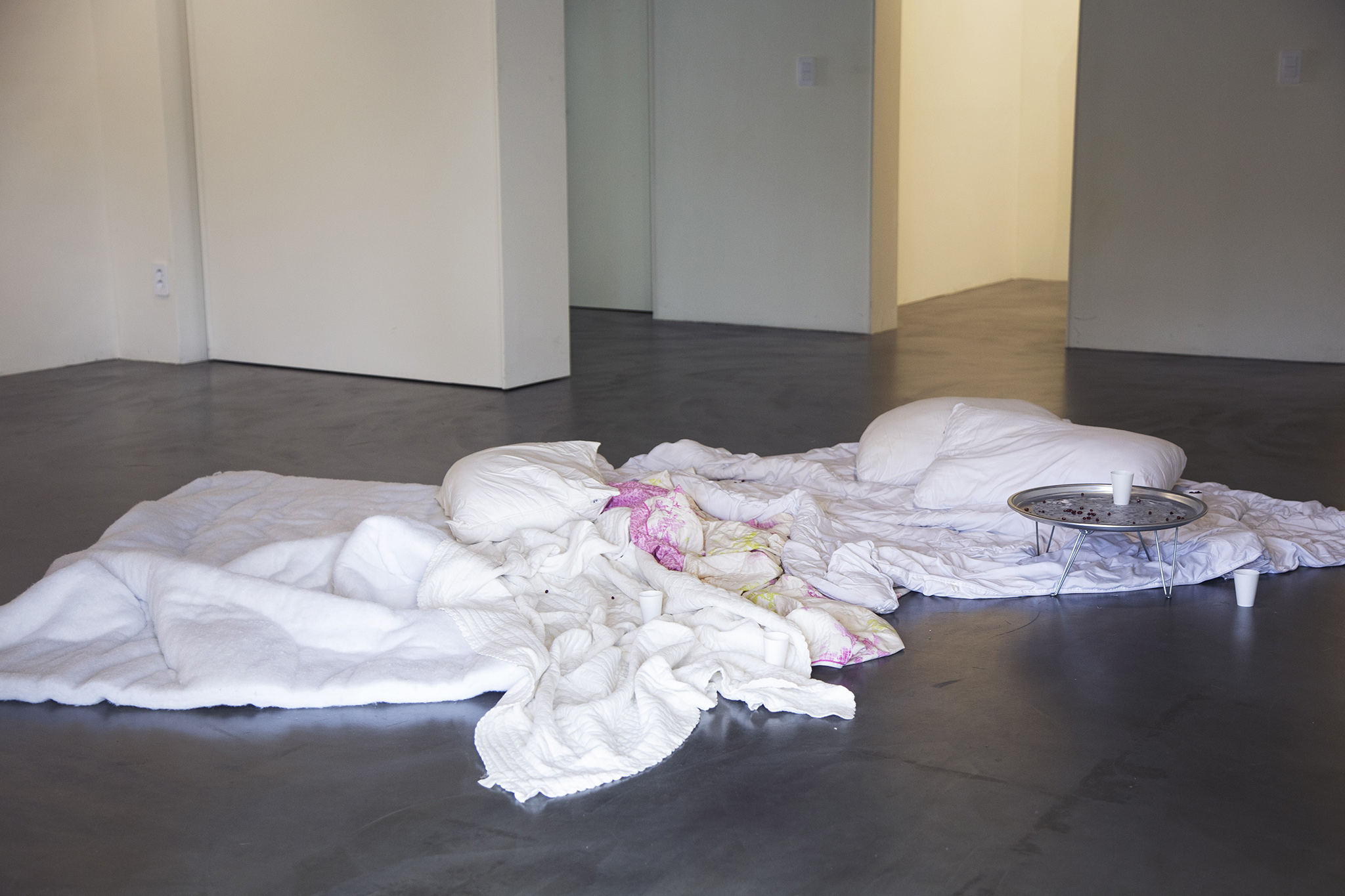 Nightmare: A Mouth Is A House (part 2) , 2024, blankets and pillows of recently deceased people, tin coated table, red beans and paper Cups