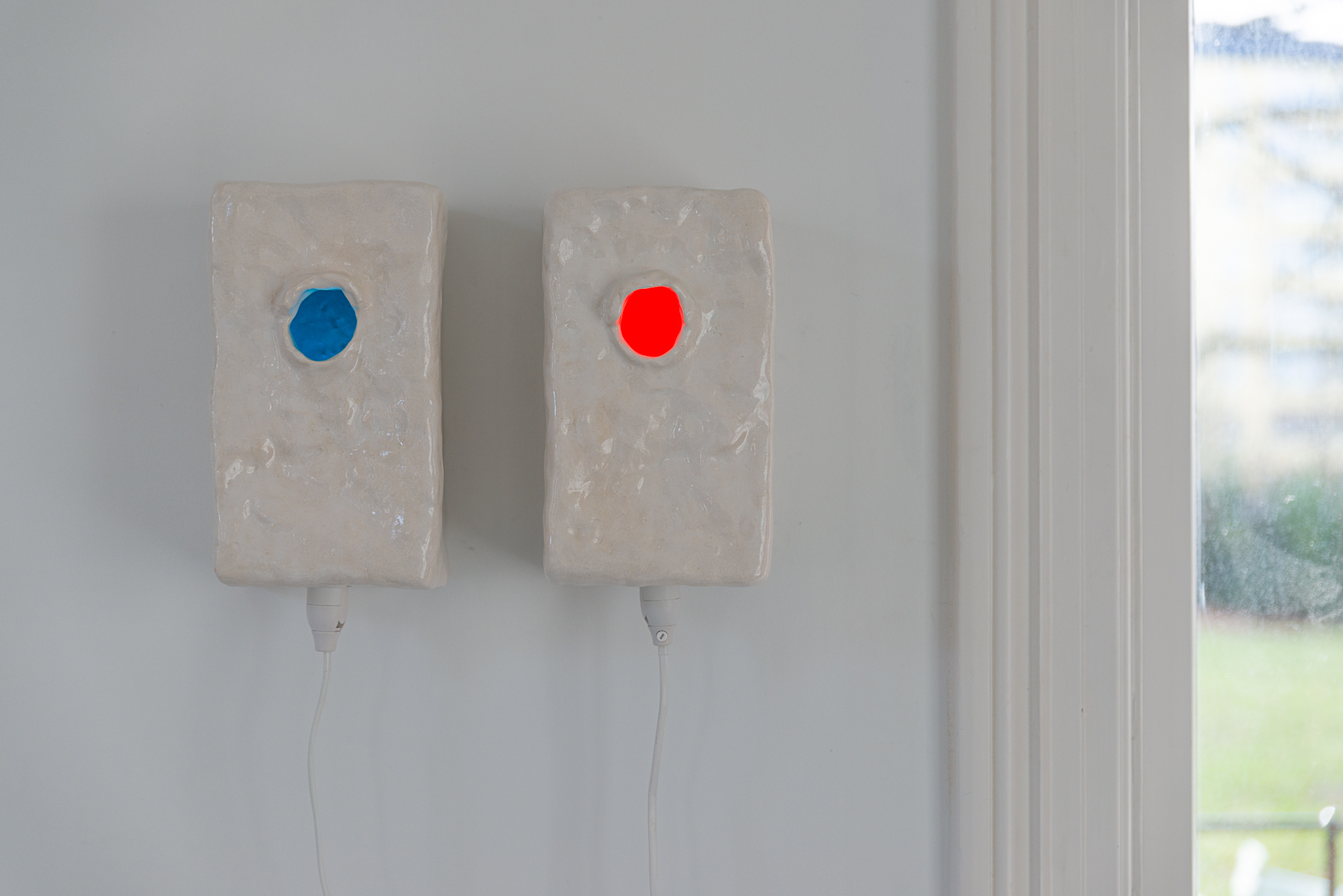 Wall pots (Chromostereopsis (blue and yellow)), (2024) Glazed stoneware, lightbulb socket, coloured light bulb. courtesy of the artist and Norwegian Sculptors Society