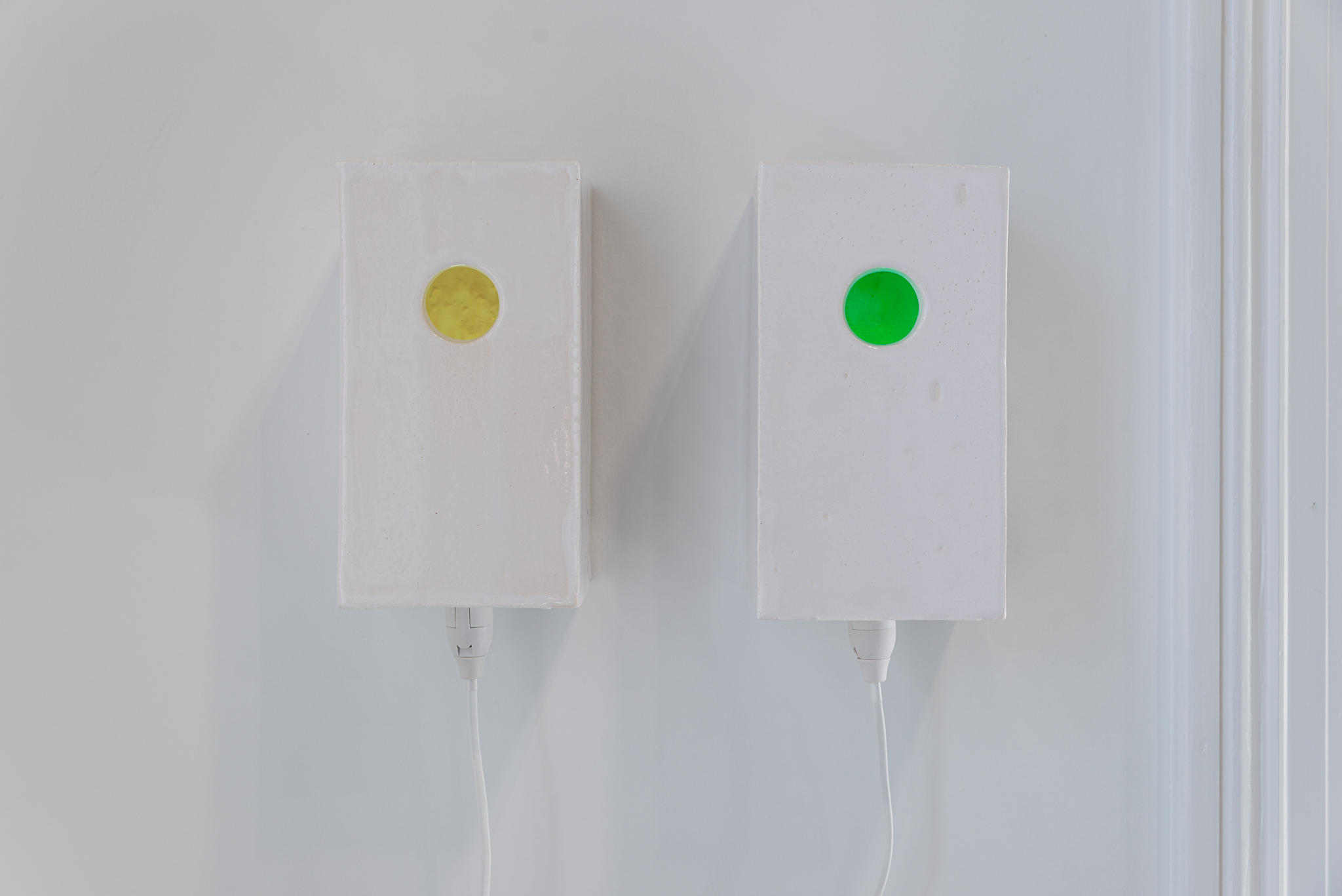 Wall pots (Chromostereopsis (yellow and green)), (2024) Glazed stoneware, lightbulb socket, coloured light bulb. courtesy of the artist and Norwegian Sculptors Society