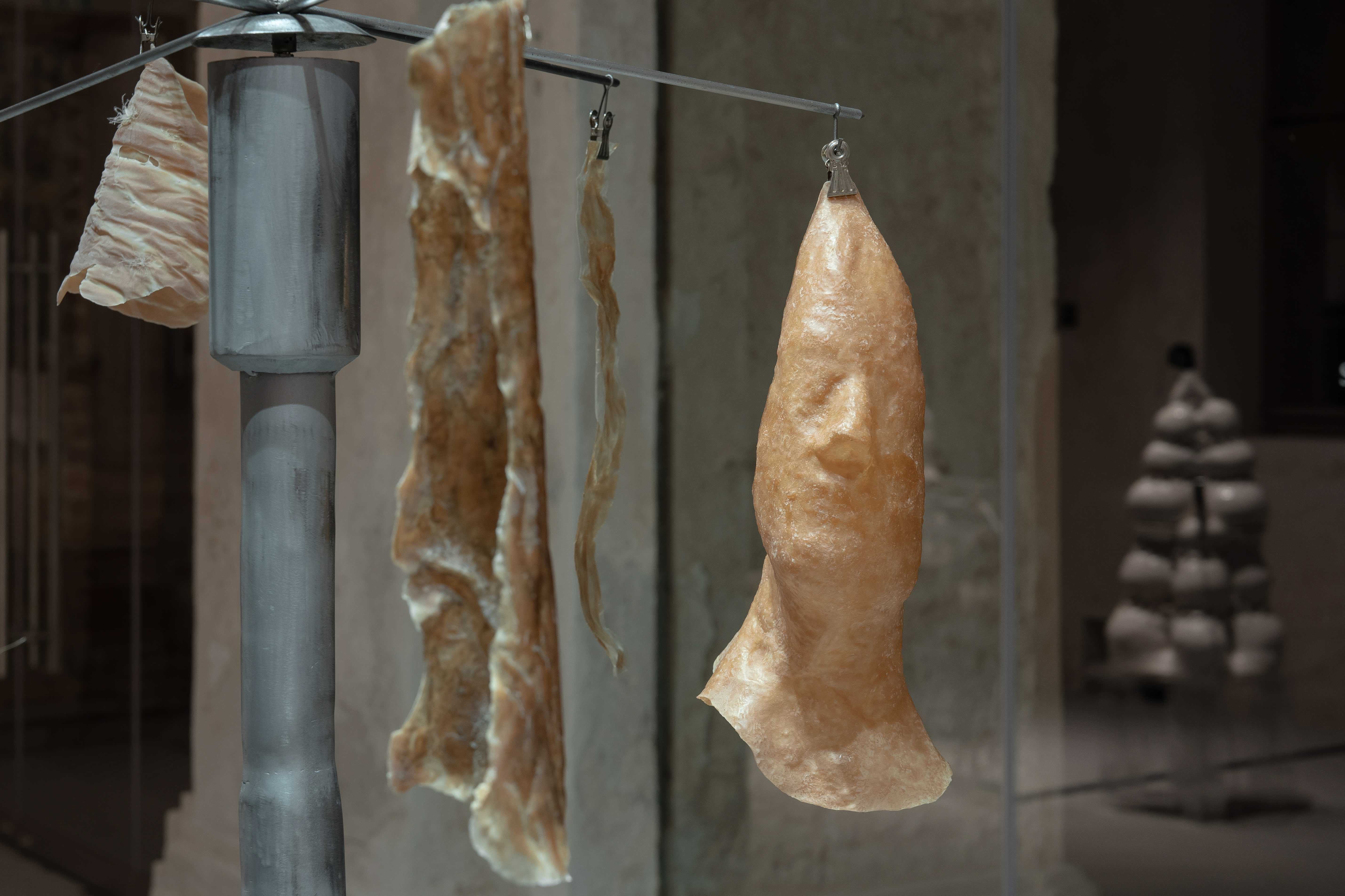 KamilÄ PikelytÄ, Vita Sintetika, 2024, found mufflers, steel, latex, collagen from rabbit skin, soap, linen fibre, snake exuvia, silicon.