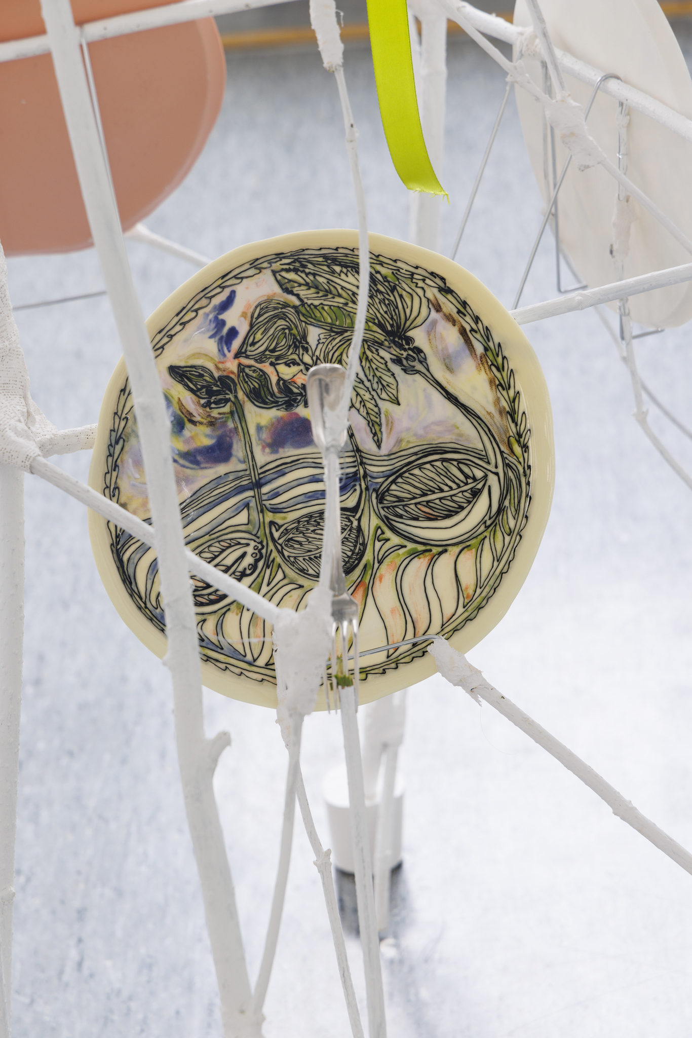 Anna Łuczak, Sophie Schmidt, “Brutality of Spring,” 2024, detail (porcelain plates, white paint, wood ribbon, metal plate holders, cutlery, make up).