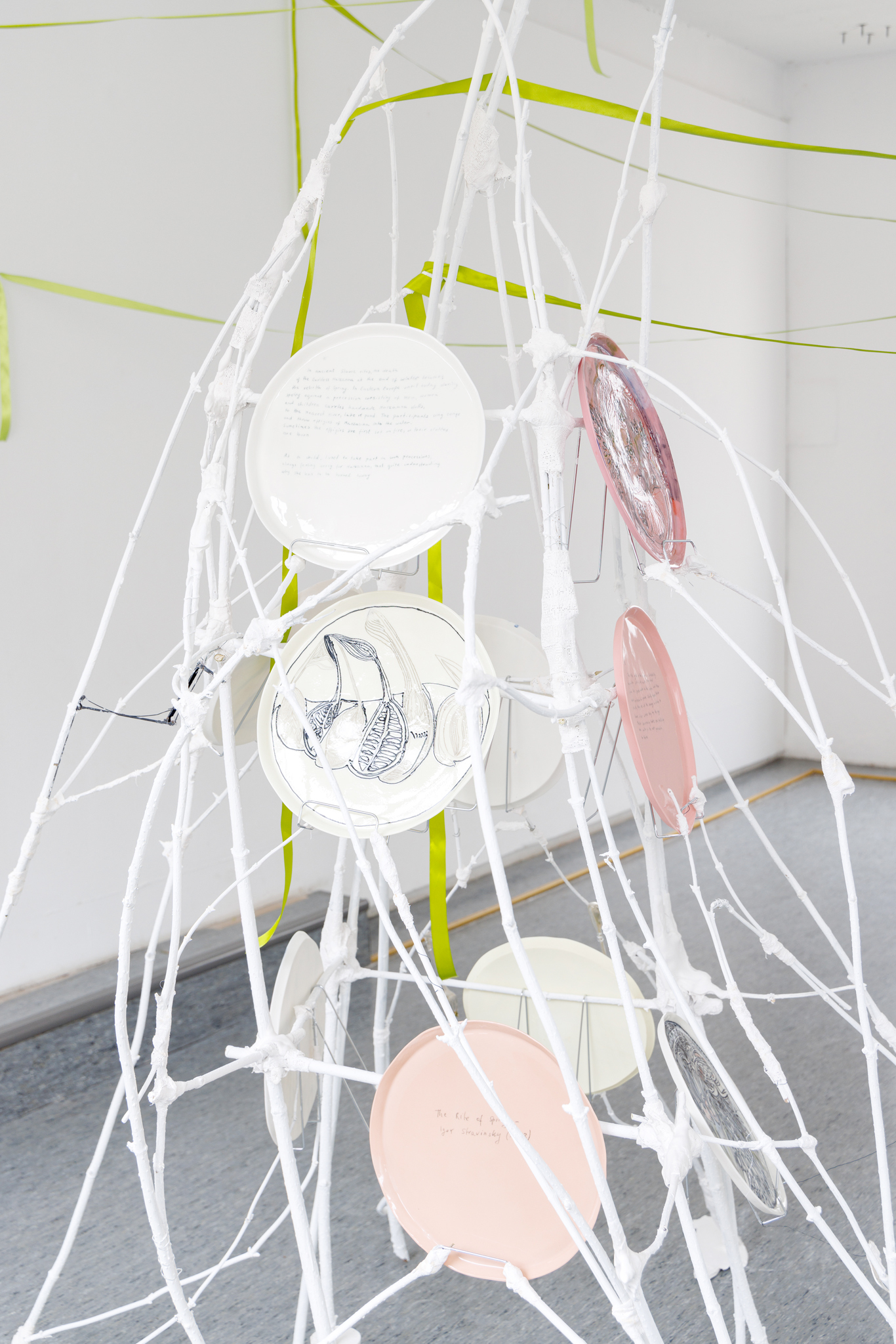Anna Łuczak, Sophie Schmidt, “Brutality of Spring,” 2024, detail (porcelain plates, white paint, wood ribbon, metal plate holders, cutlery, make up).
