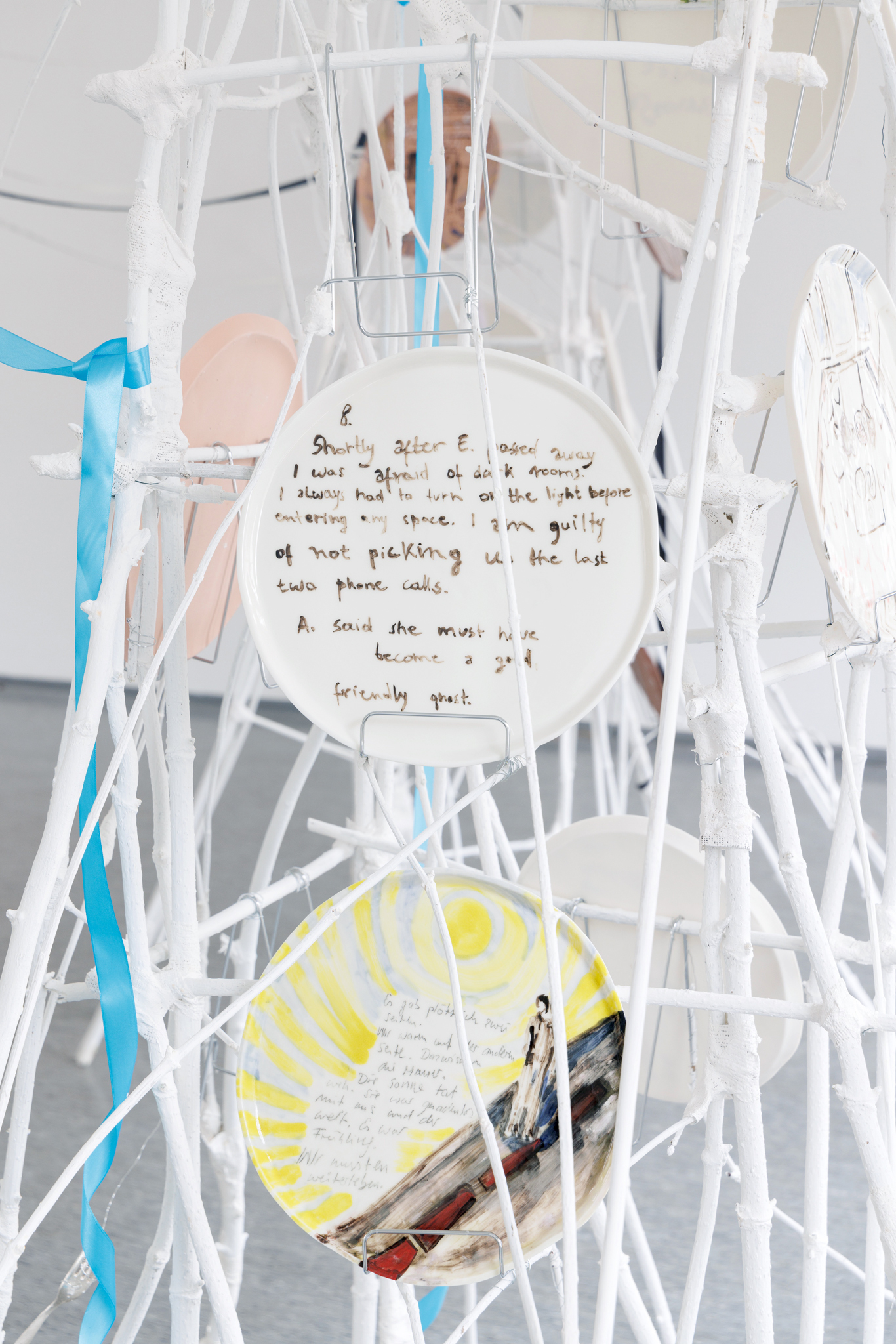 Anna Łuczak, Sophie Schmidt, “Brutality of Spring,” 2024, detail (porcelain plates, white paint, wood ribbon, metal plate holders, cutlery, make up).